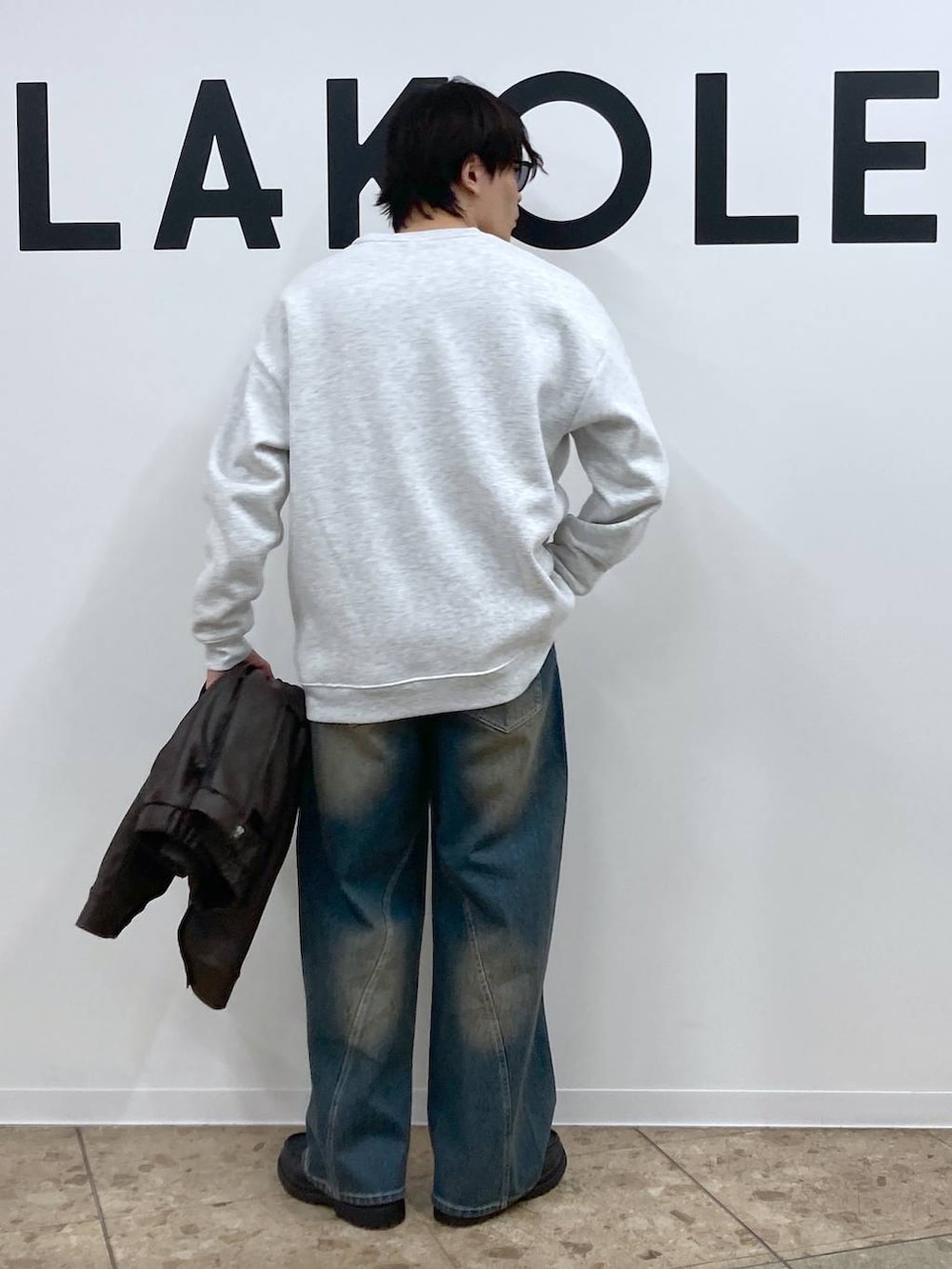 ブルー系のデニムパンツ、グレー系のスウェット、ブラック系のローファーを着用したメンズの冬コーディネートの7枚目の写真