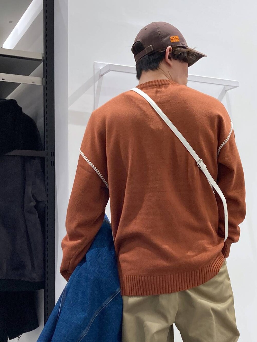 ブルー系のデニムジャケット、ベージュ系のチノパンツ、オレンジ系のニット/セーターを着用したメンズの冬コーディネートの5枚目の写真