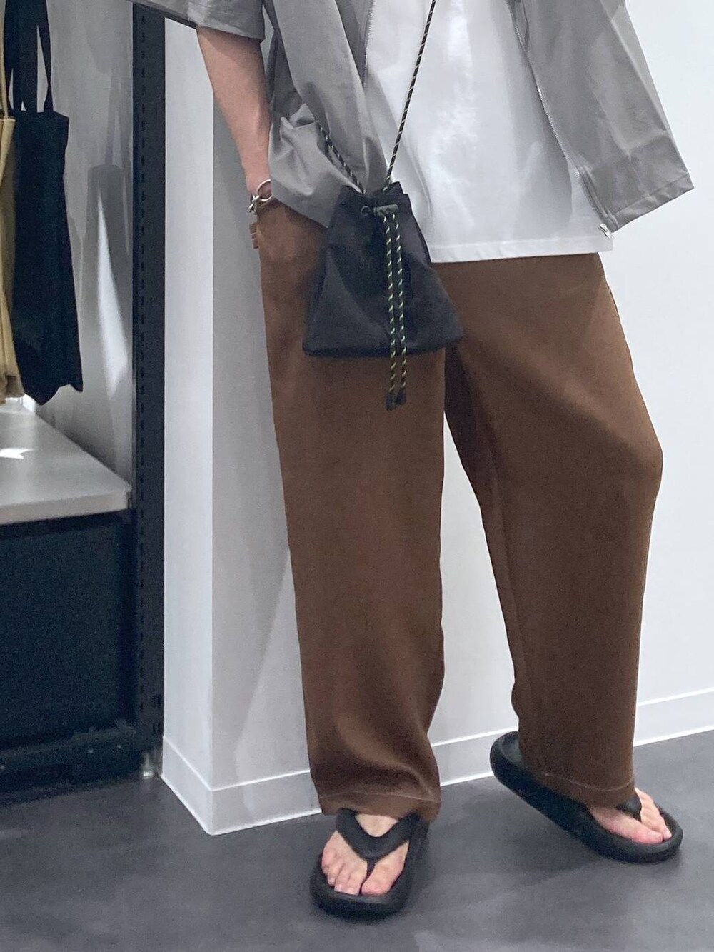 ブラック系のサンダル、ブラウン系のその他パンツ、ホワイト系のTシャツ/カットソーを着用したメンズの夏コーディネートの7枚目の写真