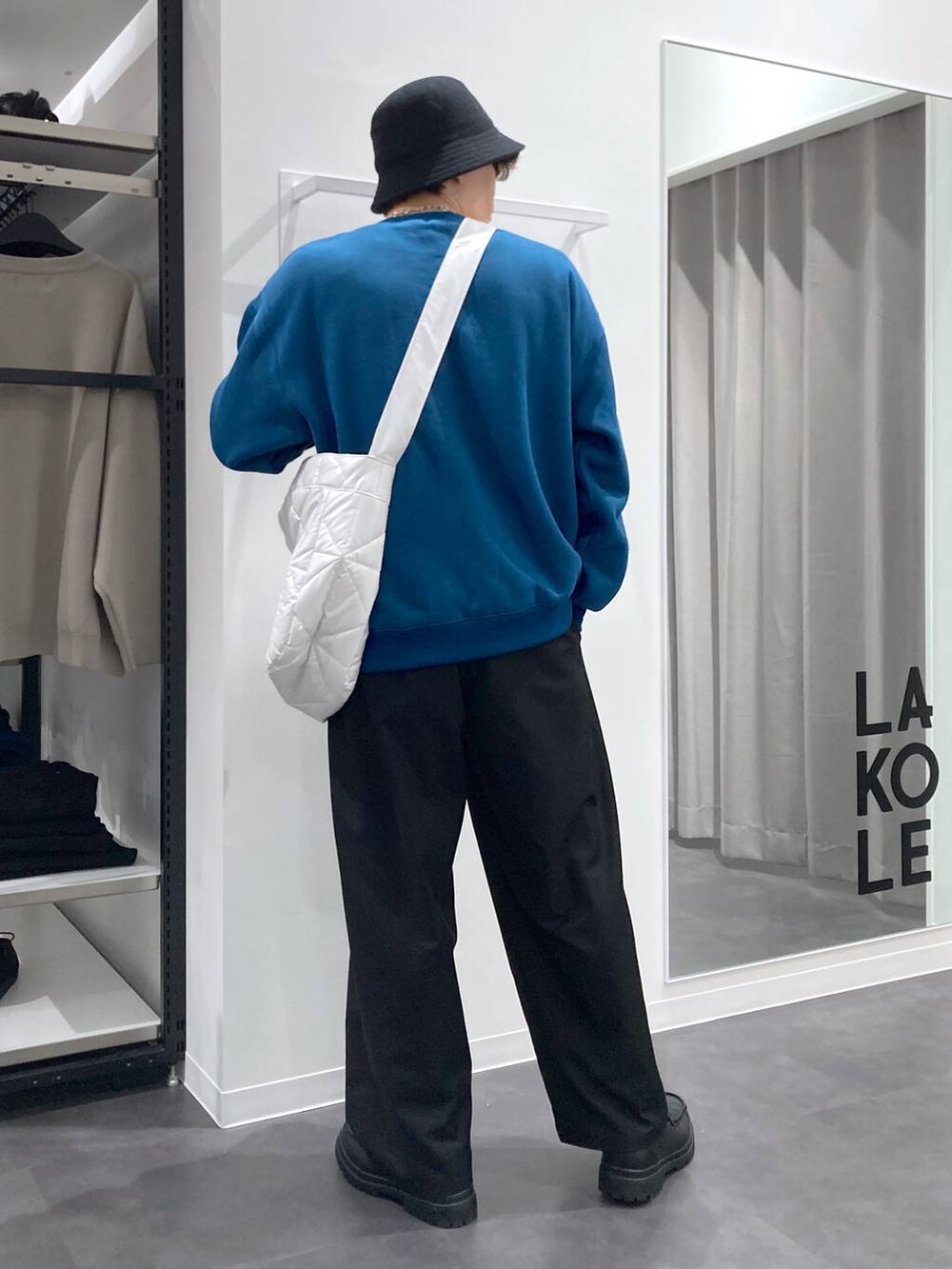 ブラック系のローファー、グリーン系のスウェット、ホワイト系のショルダーバッグを着用したメンズの冬コーディネートの2枚目の写真