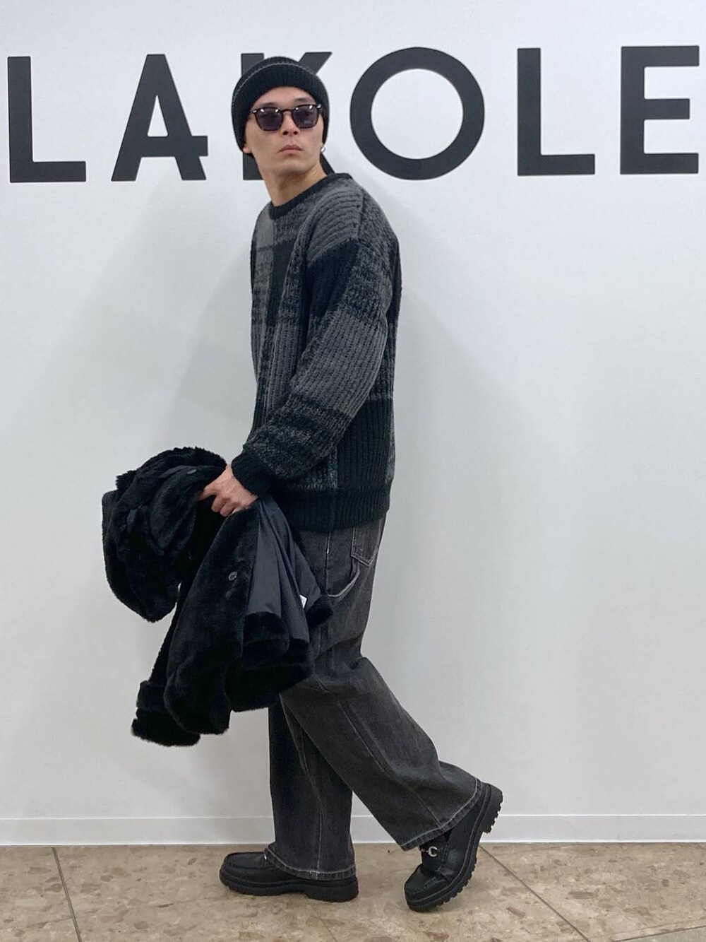 ブラック系のニット/セーター、グレー系のデニムパンツ、ブラック系のローファーを着用したメンズの冬コーディネートの7枚目の写真