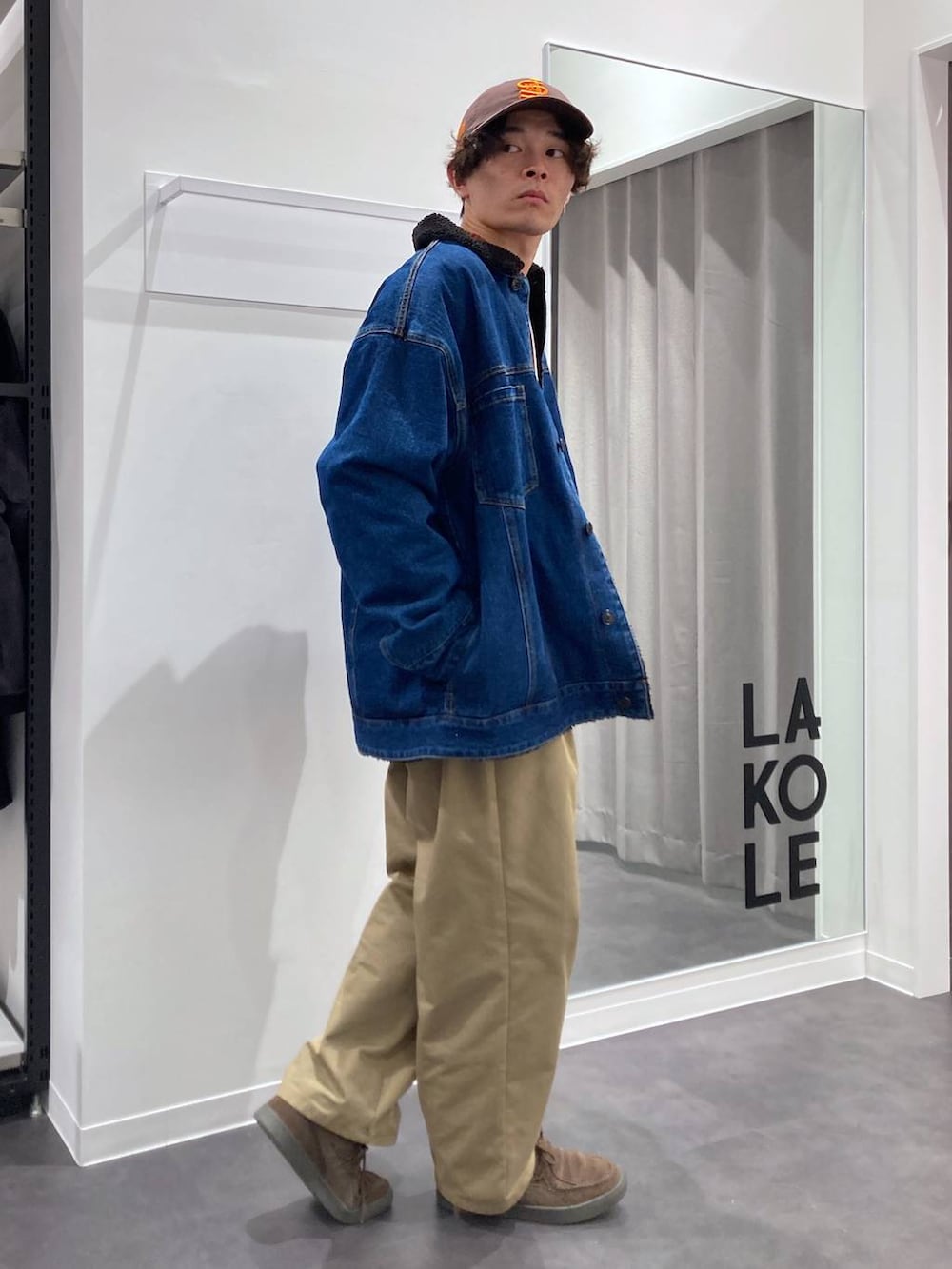 ブルー系のデニムジャケット、ベージュ系のチノパンツ、オレンジ系のニット/セーターを着用したメンズの冬コーディネートの3枚目の写真