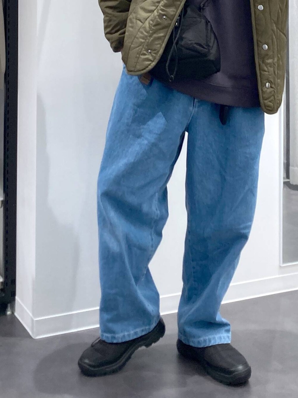 ホワイト系のパーカー、ブラック系のショルダーバッグ、グリーン系のブルゾンを着用したメンズの冬コーディネートの9枚目の写真