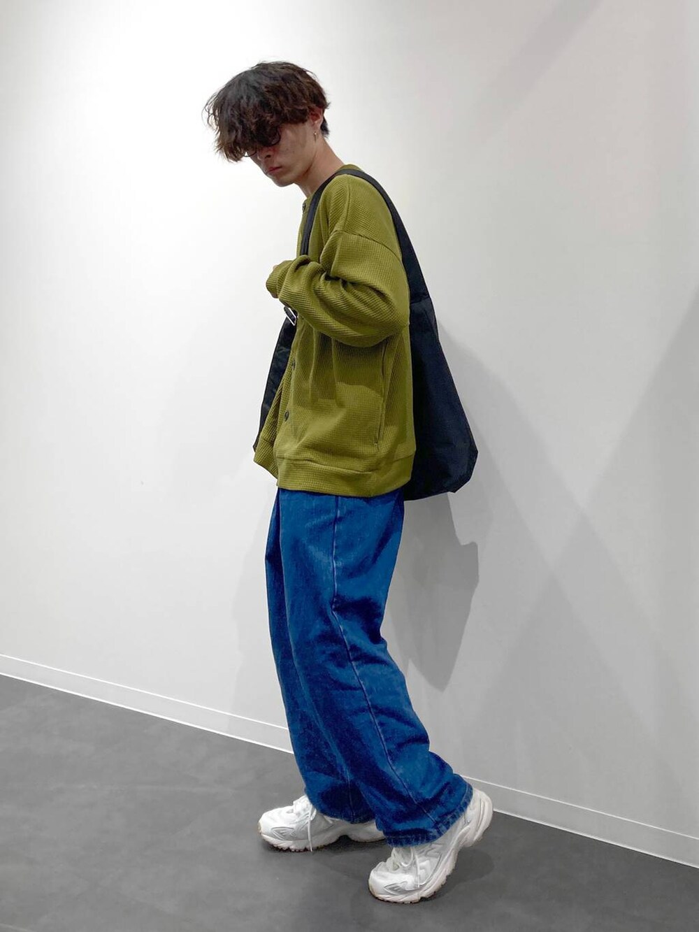 ホワイト系のスニーカー、イエロー系のTシャツ/カットソー、ブルー系のデニムパンツを着用したメンズの秋コーディネートの3枚目の写真