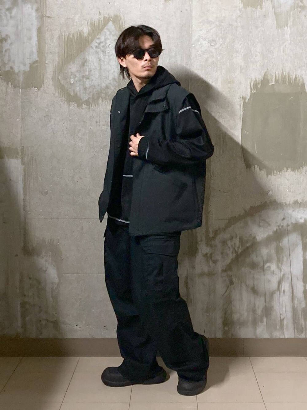 ブラック系のTシャツ/カットソー、ブラック系のカーゴパンツ、ブラック系のブルゾンを着用したメンズの秋コーディネートの3枚目の写真