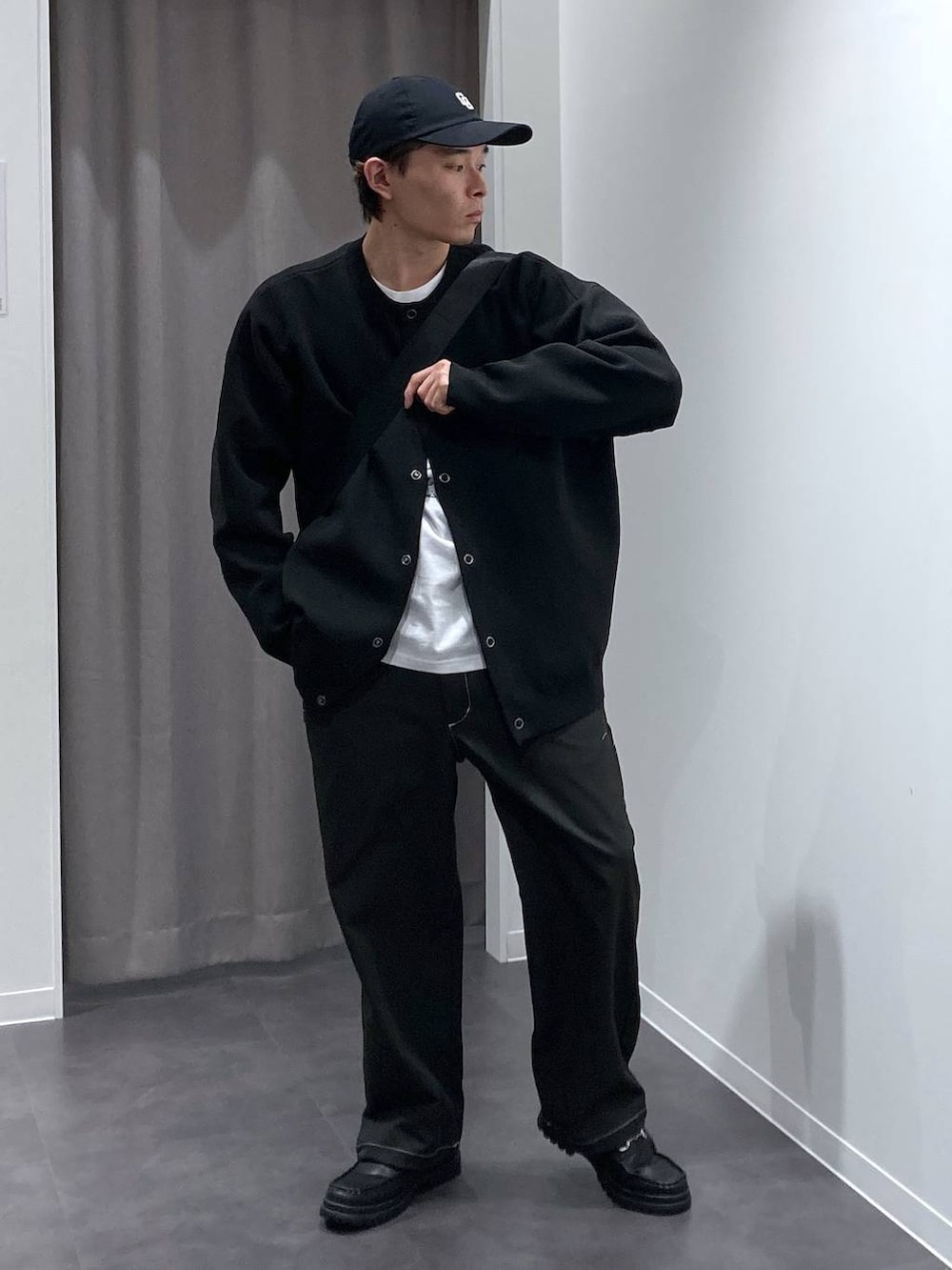 ブラック系のその他パンツ、ブラック系のローファー、ブラック系のメッセンジャーバッグを着用したメンズの冬コーディネートの5枚目の写真