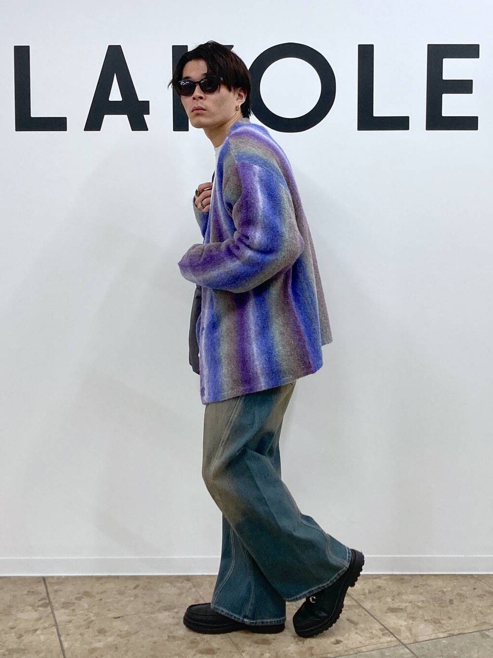 ブルー系のデニムパンツ、パープル系のカーディガン/ボレロ、グレー系のスウェットを着用したメンズの冬コーディネートの3枚目の写真