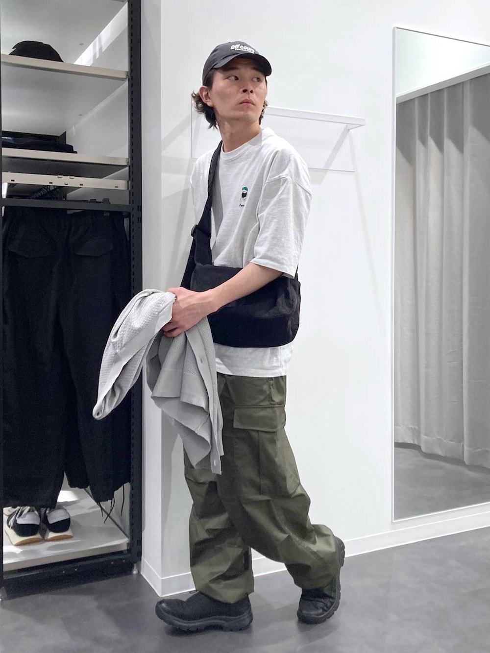 グレー系のTシャツ/カットソー、ブラック系のスリッポン、グリーン系のカーゴパンツを着用したメンズの春コーディネートの8枚目の写真