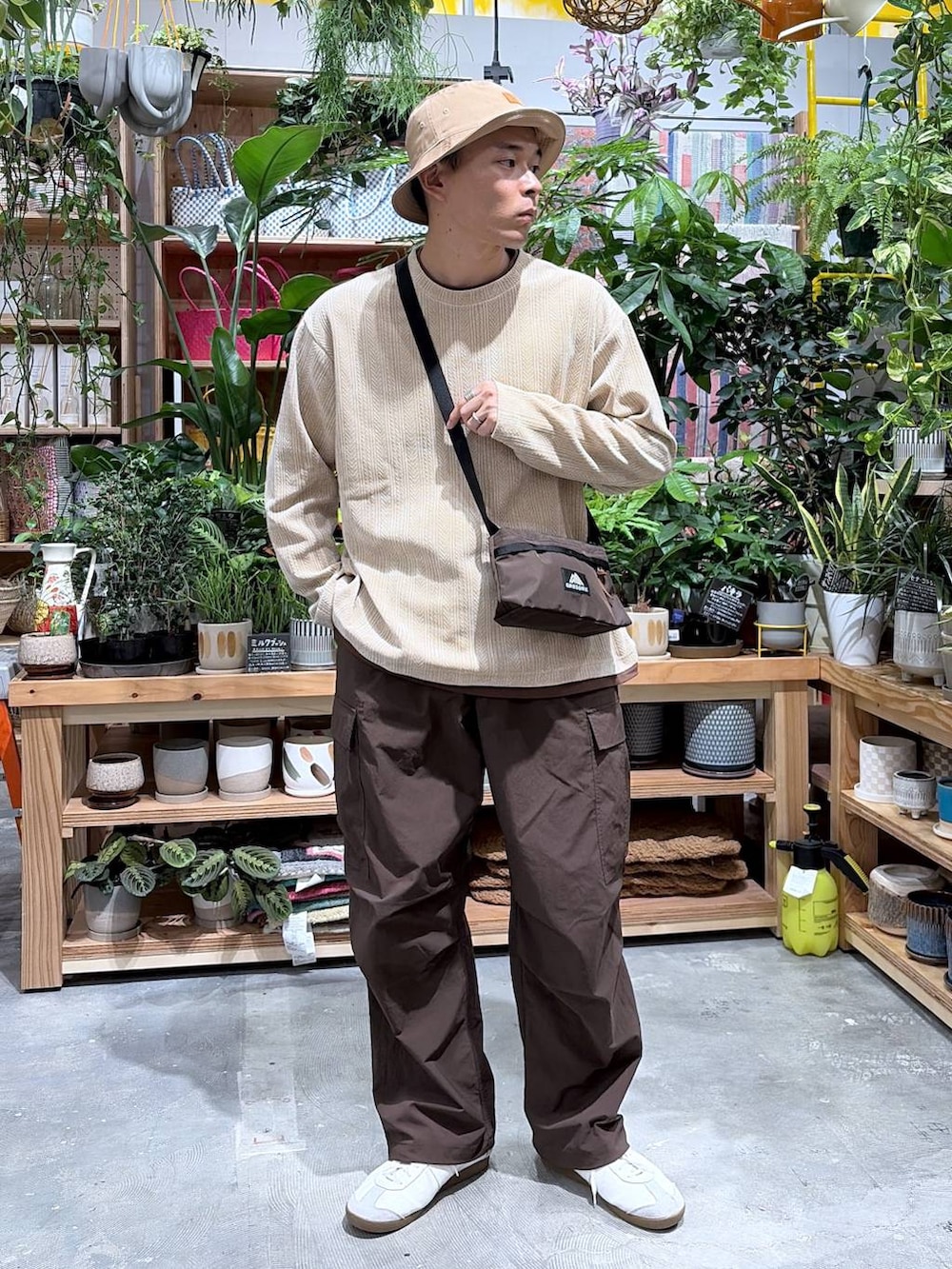 ベージュ系のTシャツ/カットソー、ブラウン系のカーゴパンツ、ベージュ系のハットを着用したメンズの秋コーディネートの5枚目の写真