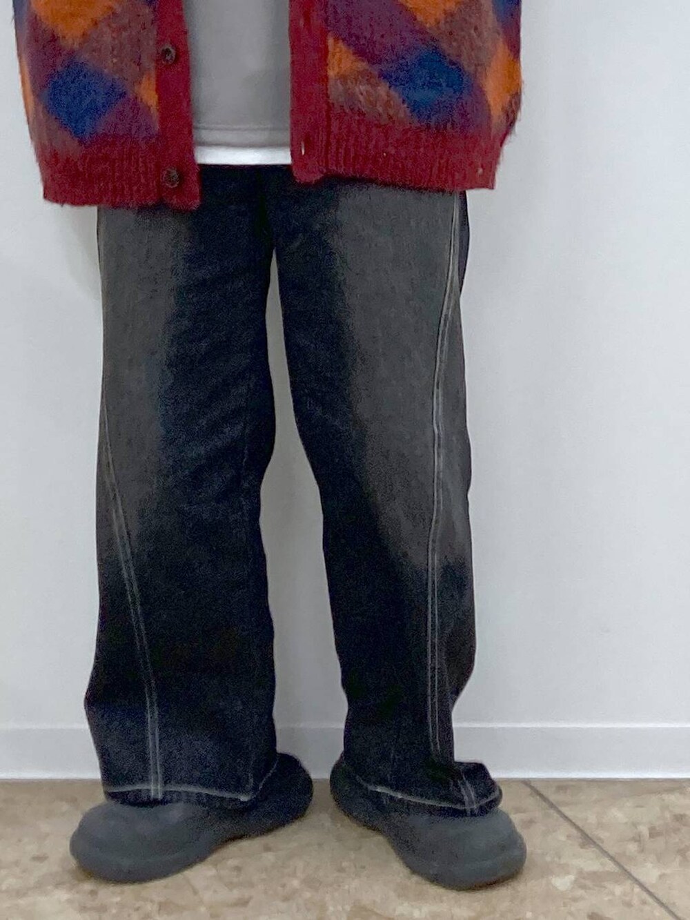 オレンジ系のカーディガン/ボレロ、グレー系のTシャツ/カットソー、ブラック系のデニムパンツを着用したメンズの冬コーディネートの5枚目の写真