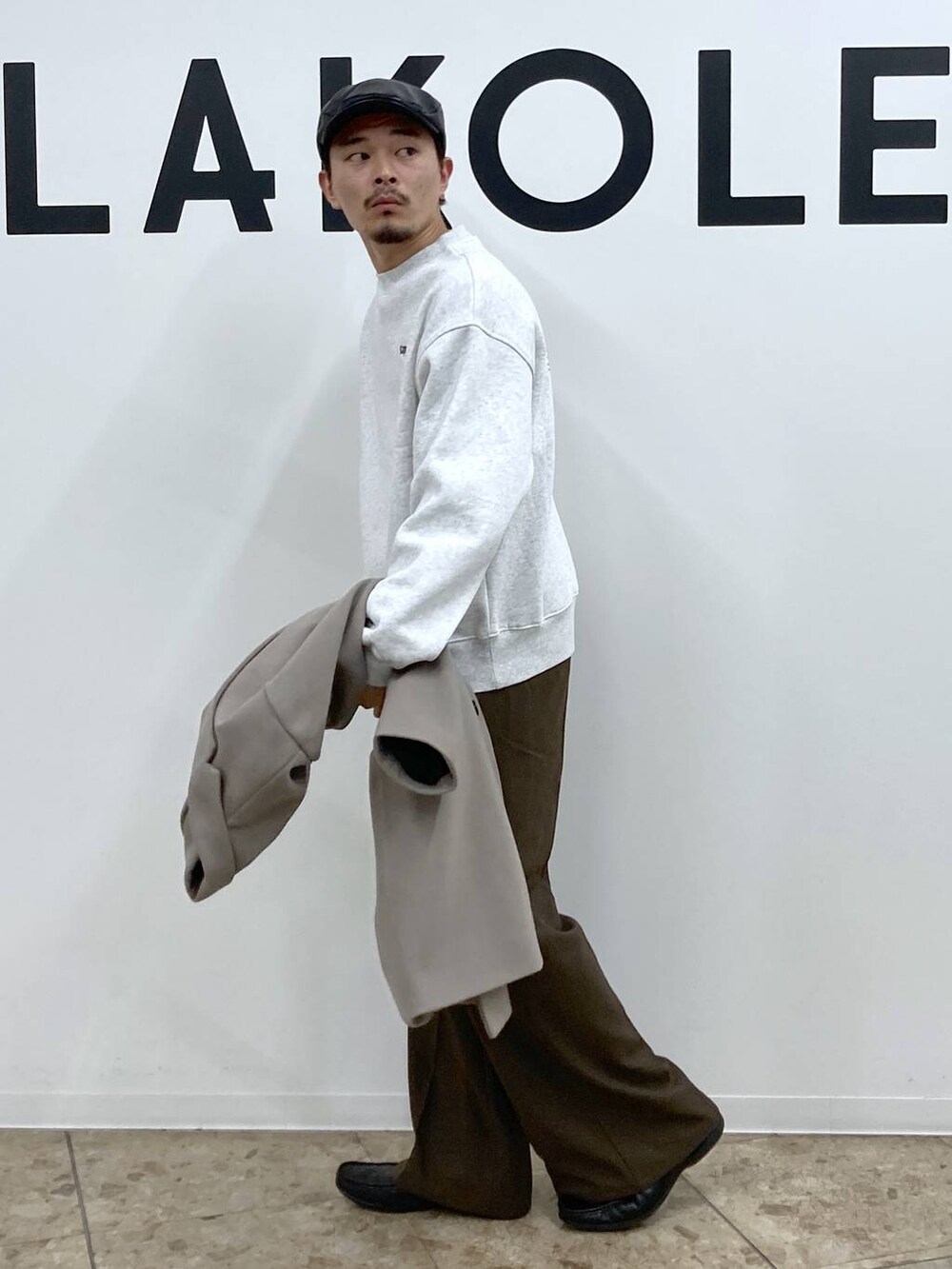 ホワイト系のチェスターコート、ブラウン系のその他パンツ、ブラック系のハンチング/ベレー帽を着用したメンズの秋コーディネートの6枚目の写真