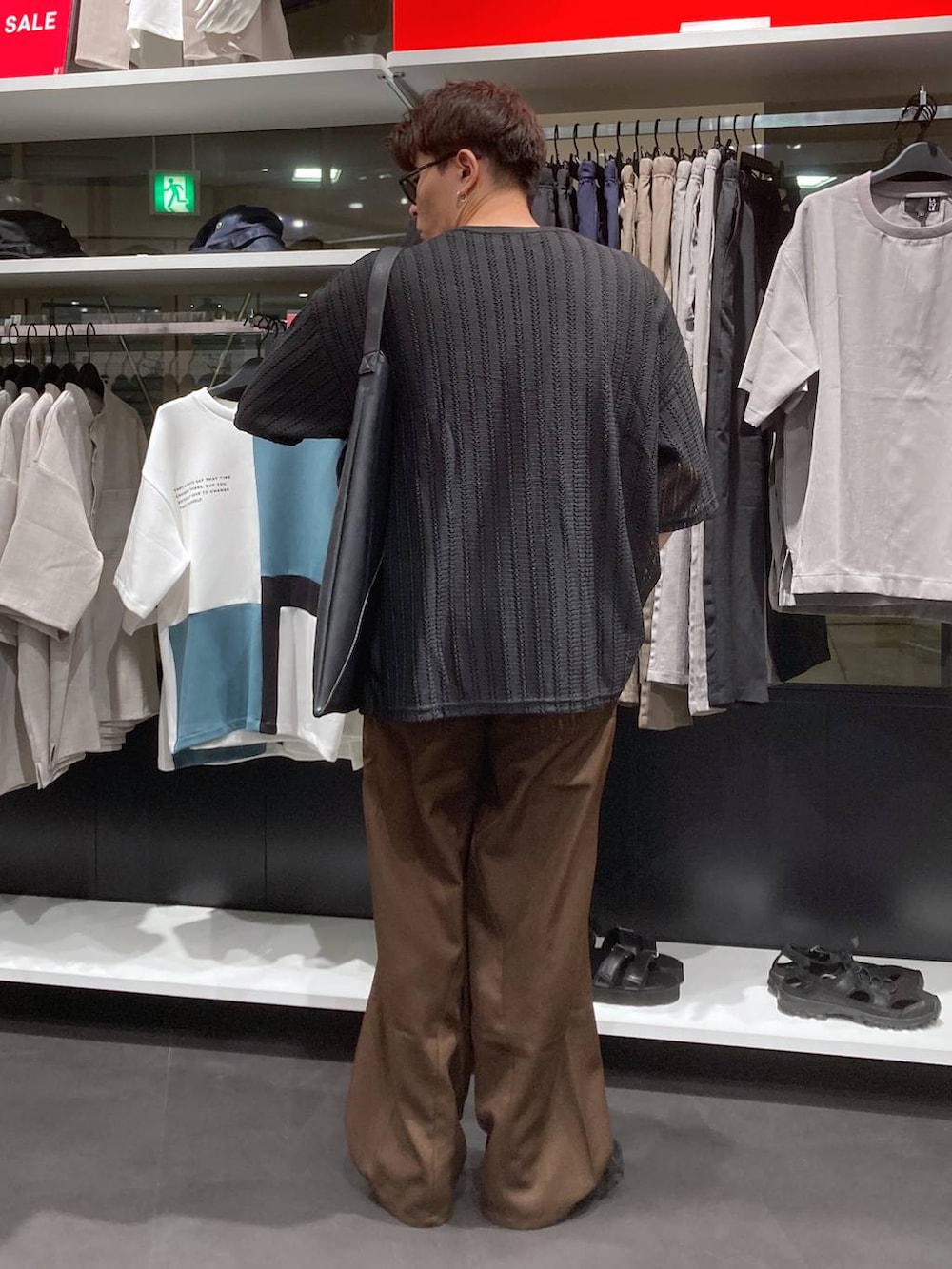 ブラック系のサンダル、ブラック系のTシャツ/カットソー、ブラック系のトートバッグを着用したメンズの夏コーディネートの2枚目の写真