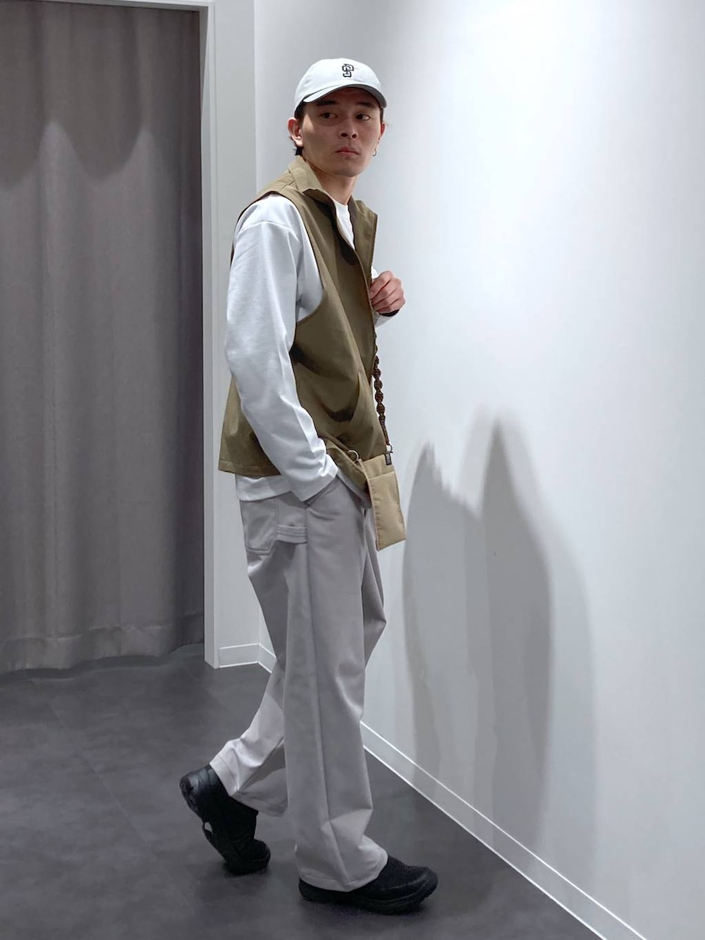 ベージュ系のベスト、グレー系のその他パンツ、ブラック系のスリッポンを着用したメンズの冬コーディネートの3枚目の写真