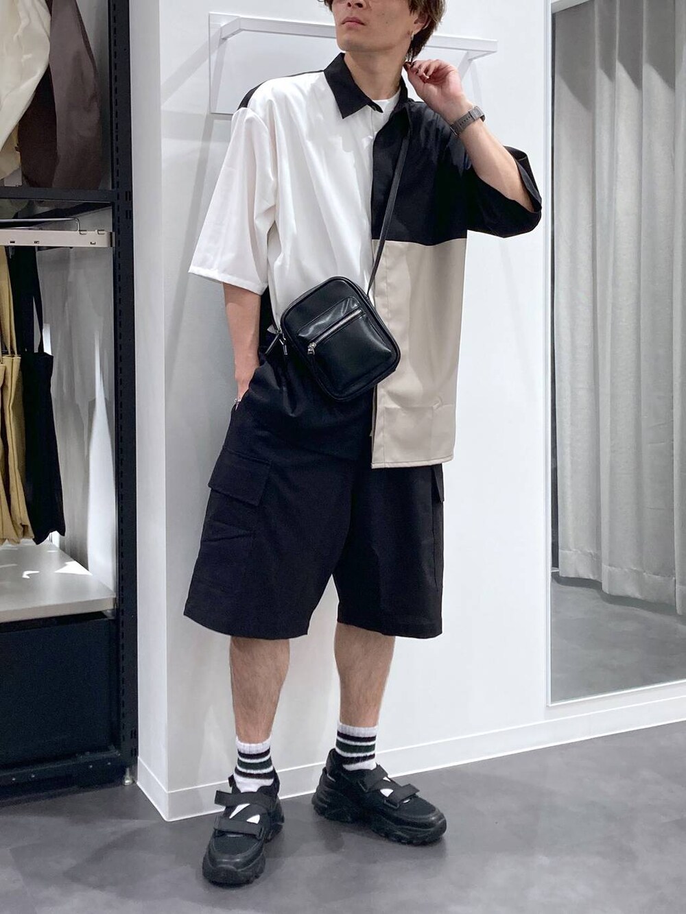 ブラック系のスニーカー、ホワイト系のTシャツ/カットソー、ブラック系のショルダーバッグを着用したメンズの夏コーディネートの5枚目の写真
