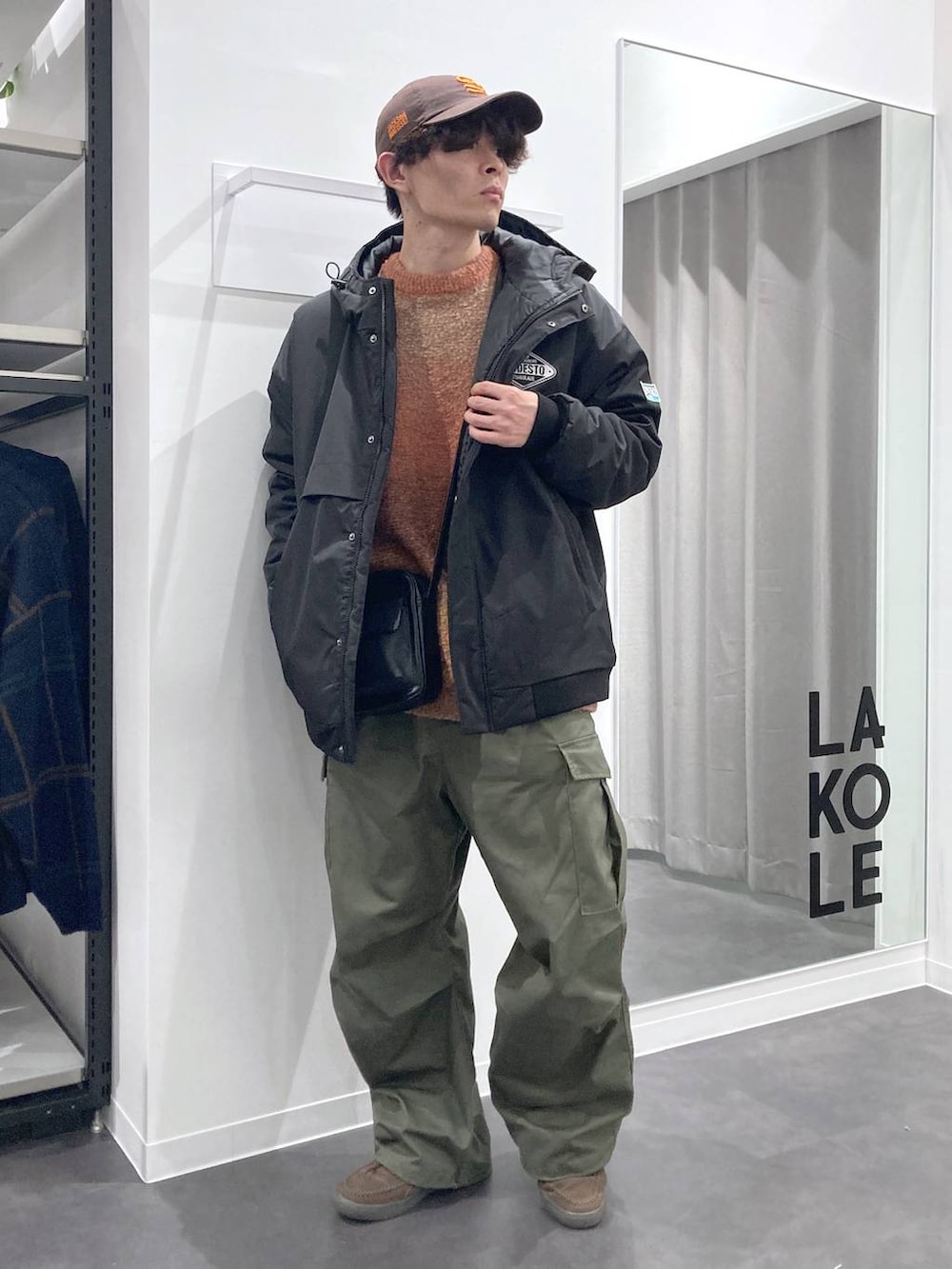 オレンジ系のニット/セーター、ブラック系のショルダーバッグ、ブラック系のブルゾンを着用したメンズの冬コーディネートの8枚目の写真