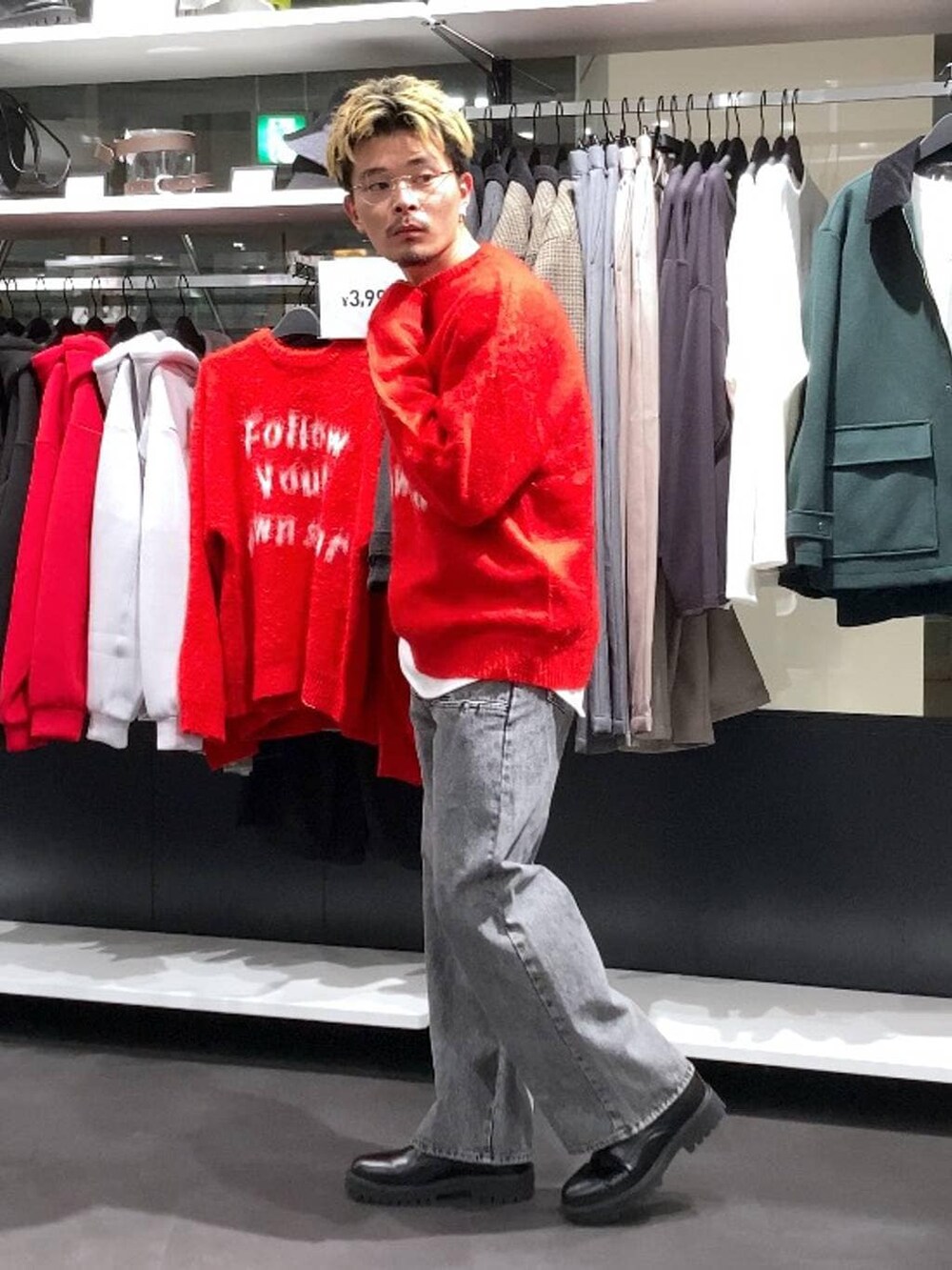 レッド系のニット/セーター、ブラック系のドレスシューズ、グレー系のデニムパンツを着用したメンズの冬コーディネートの3枚目の写真