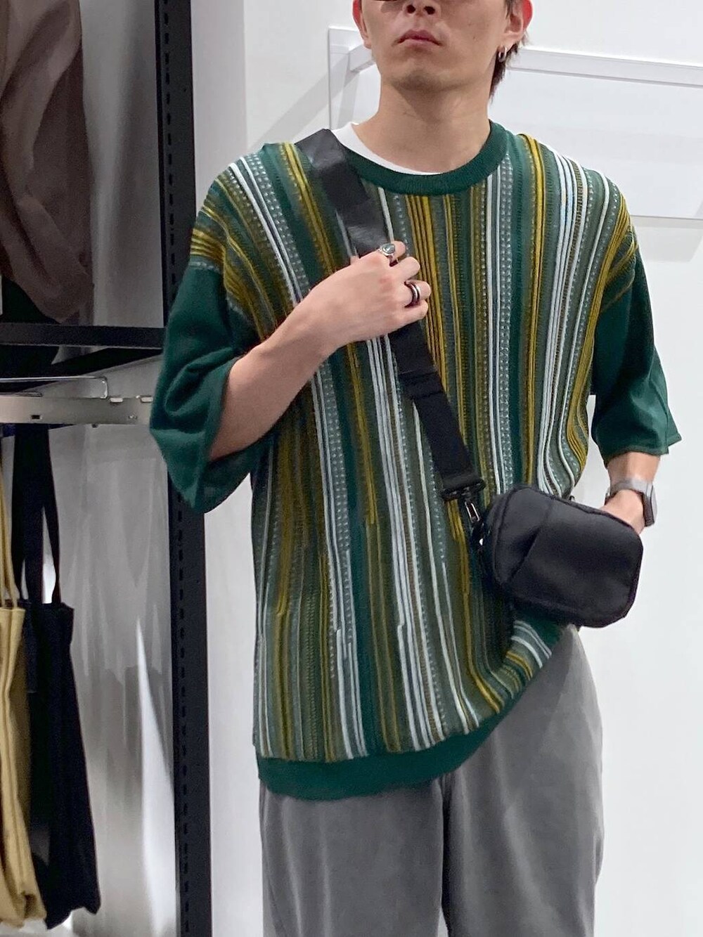 ブラック系のスニーカー、ブラック系のボディバッグ/ウエストポーチ、ホワイト系のTシャツ/カットソーを着用したメンズの夏コーディネートの4枚目の写真