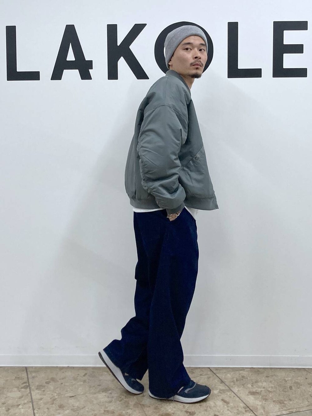 ブルー系のスニーカー、グリーン系のブルゾン、ブルー系のデニムパンツを着用したメンズの冬コーディネートの4枚目の写真