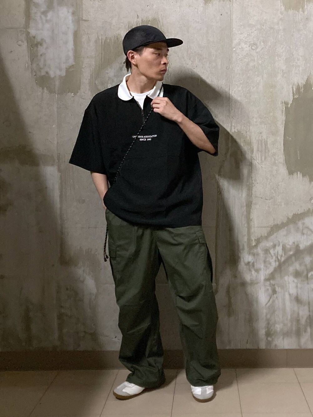 ホワイト系のTシャツ/カットソー、グリーン系のカーゴパンツ、ブラック系のショルダーバッグを着用したメンズの夏コーディネートの5枚目の写真