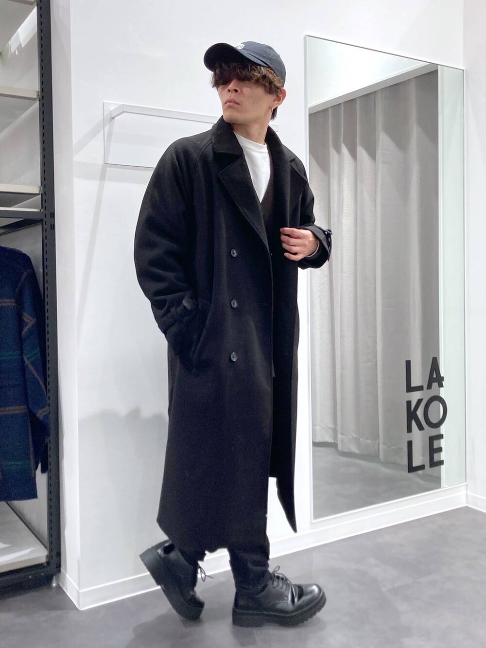 ブラック系のトレンチコート、グレー系のTシャツ/カットソー、ホワイト系のスウェットを着用したメンズの冬コーディネートの3枚目の写真