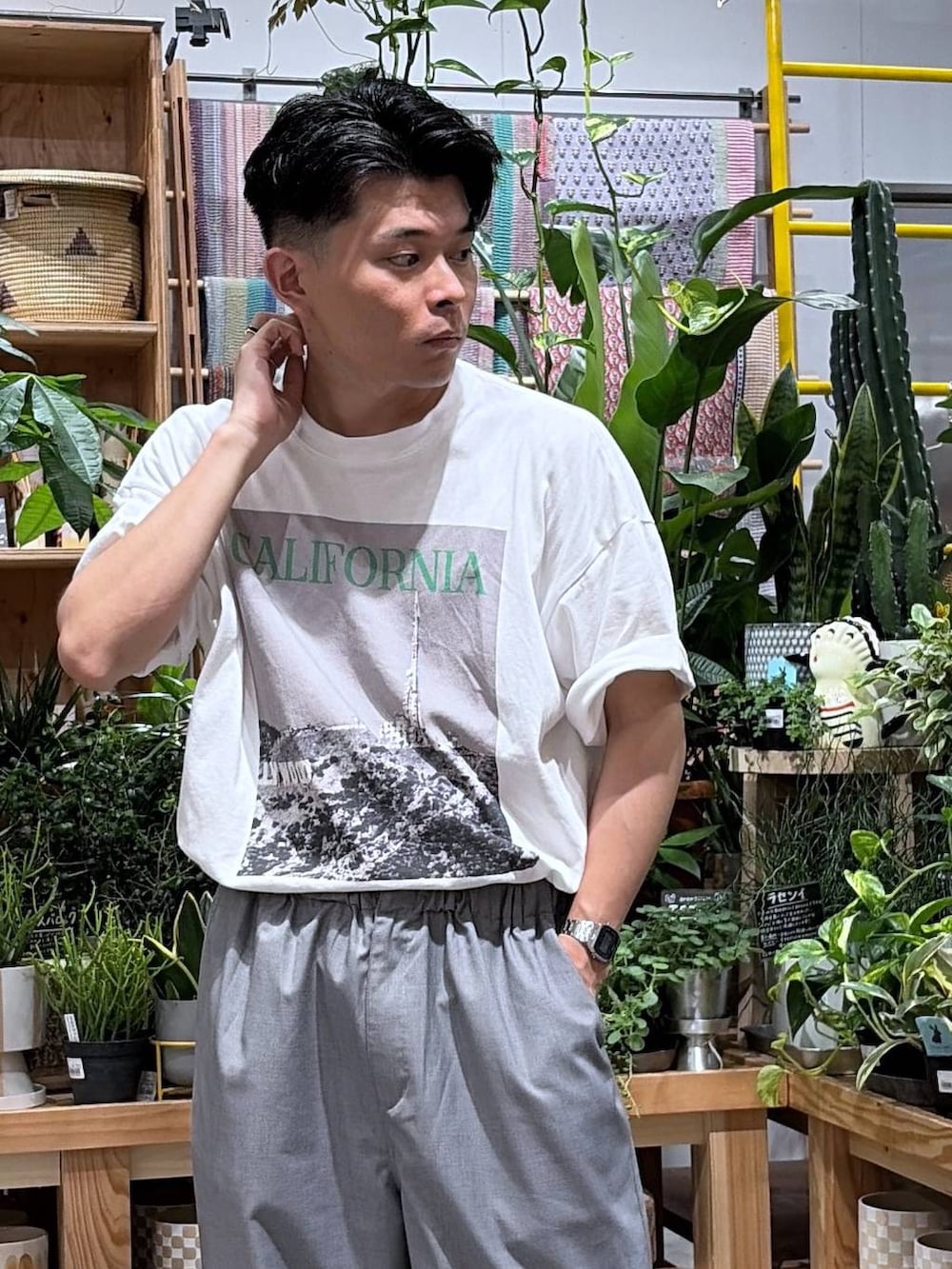 グレー系のスラックス、ホワイト系のTシャツ/カットソーを着用したメンズの夏コーディネートの5枚目の写真
