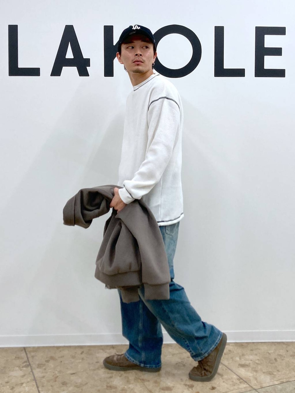 ブラウン系のブルゾン、ブルー系のデニムパンツ、ホワイト系のTシャツ/カットソーを着用したメンズの秋コーディネートの7枚目の写真