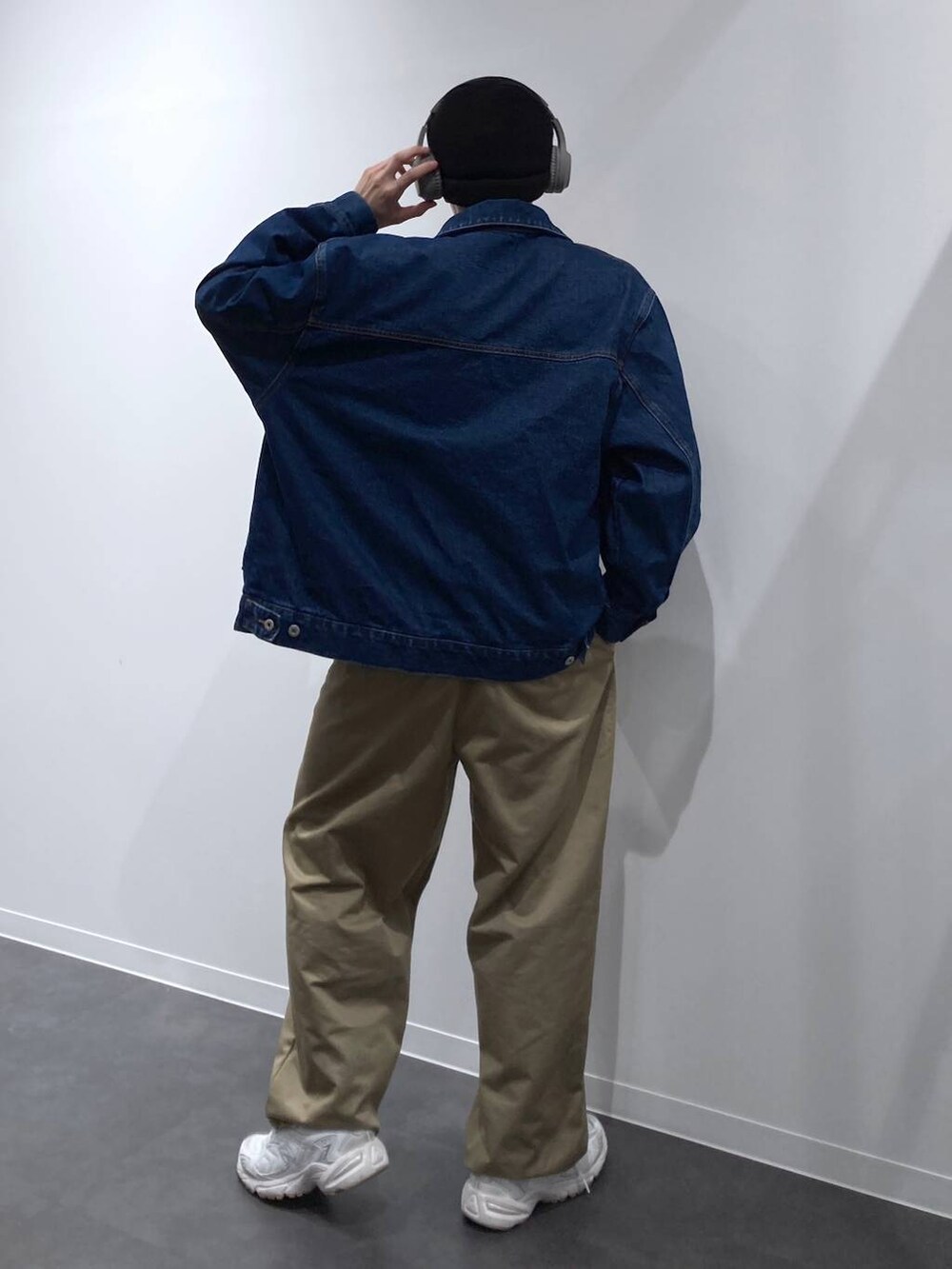 ブラック系のボディバッグ/ウエストポーチ、ホワイト系のスニーカー、ブルー系のデニムジャケットを着用したメンズの秋コーディネートの2枚目の写真