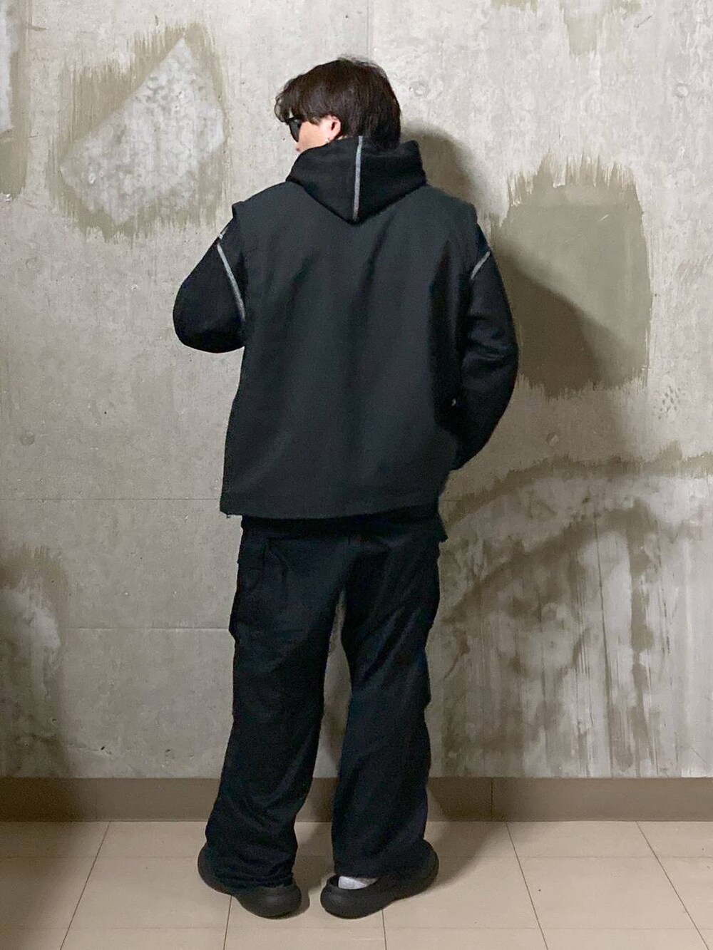 ブラック系のTシャツ/カットソー、ブラック系のカーゴパンツ、ブラック系のブルゾンを着用したメンズの秋コーディネートの2枚目の写真