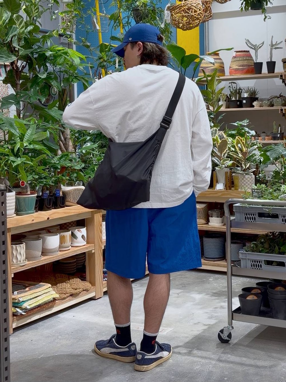 ブラック系のエコバッグ/サブバッグ、ホワイト系のTシャツ/カットソー、ブルー系のその他パンツを着用したメンズの春コーディネートの2枚目の写真