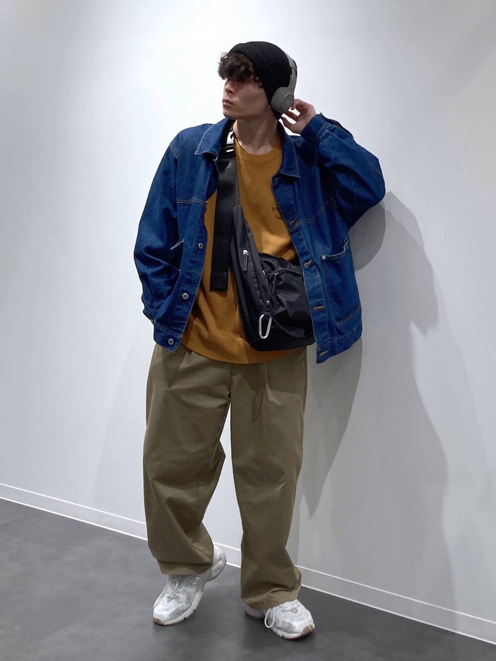 ブラック系のボディバッグ/ウエストポーチ、ホワイト系のスニーカー、ブルー系のデニムジャケットを着用したメンズの秋コーディネートの4枚目の写真