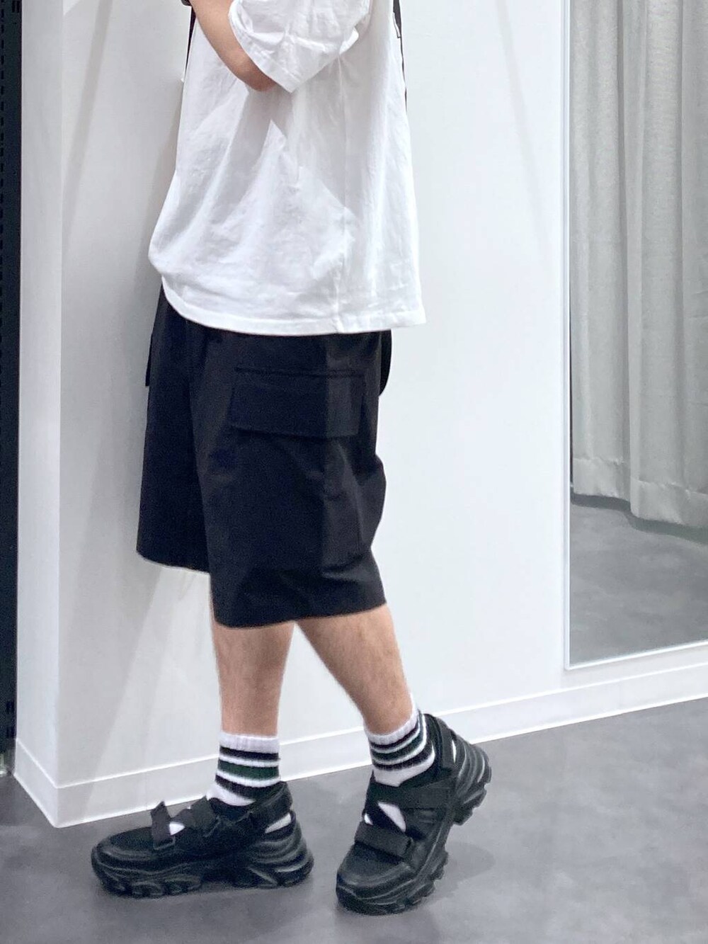 ブラック系のスニーカー、ブラック系のバックパック/リュック、ホワイト系のTシャツ/カットソーを着用したメンズの夏コーディネートの10枚目の写真