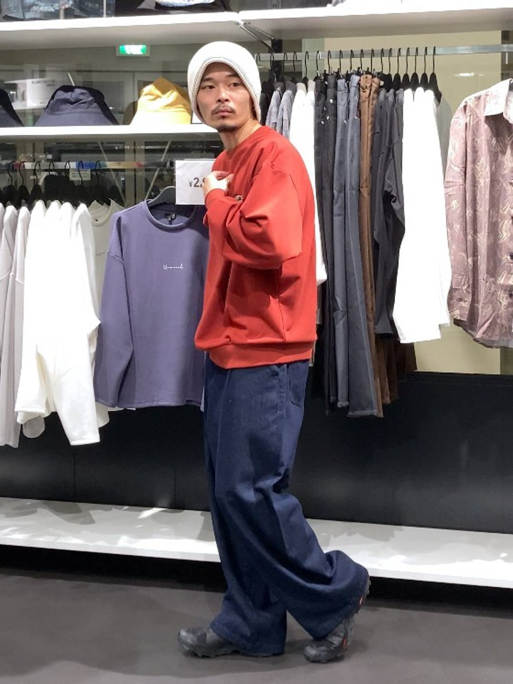 ブルー系のデニムパンツ、レッド系のスウェット、ベージュ系のニットキャップ/ビーニーを着用したメンズの秋コーディネートの3枚目の写真