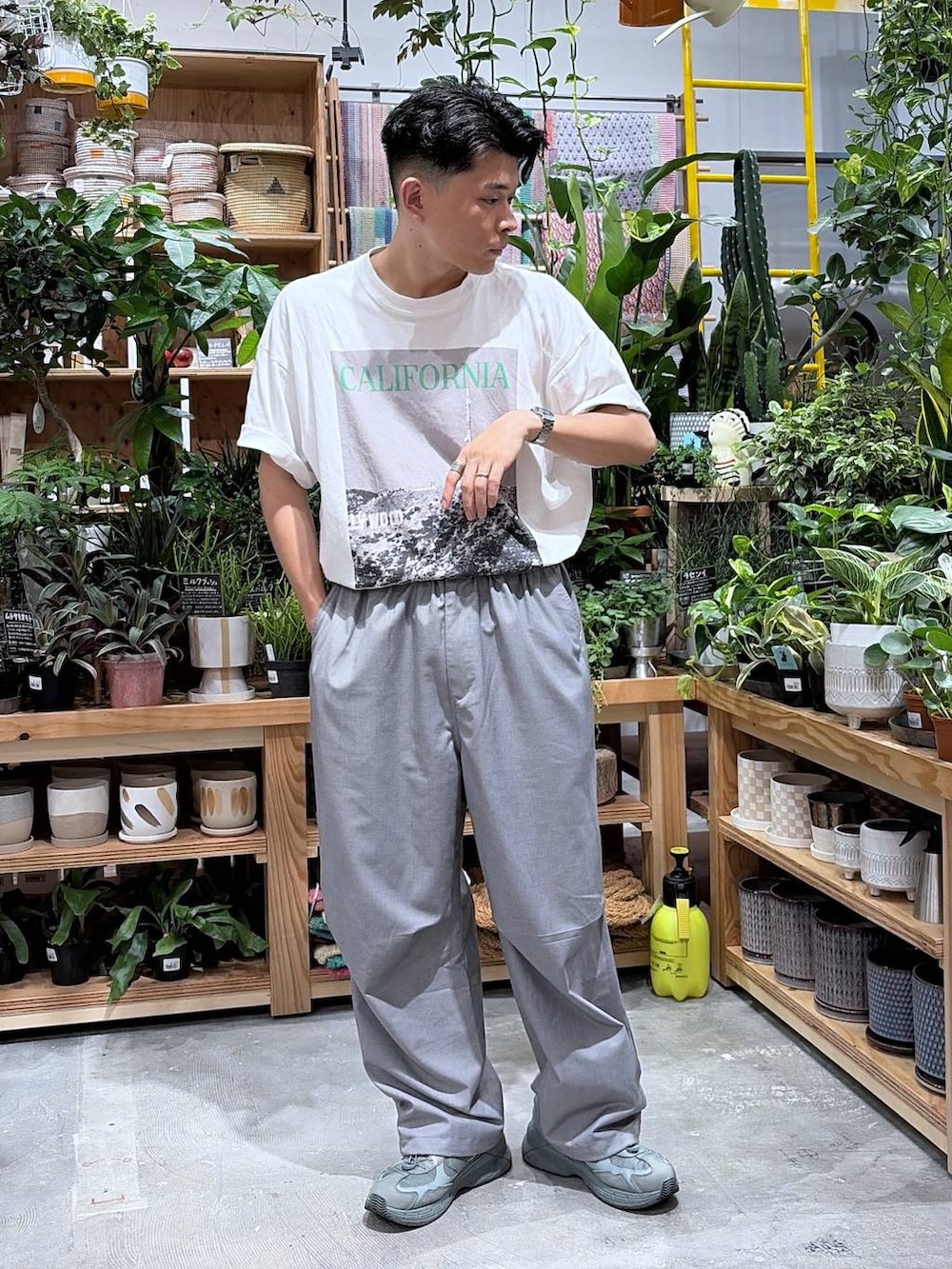 グレー系のスラックス、ホワイト系のTシャツ/カットソーを着用したメンズの夏コーディネートの6枚目の写真