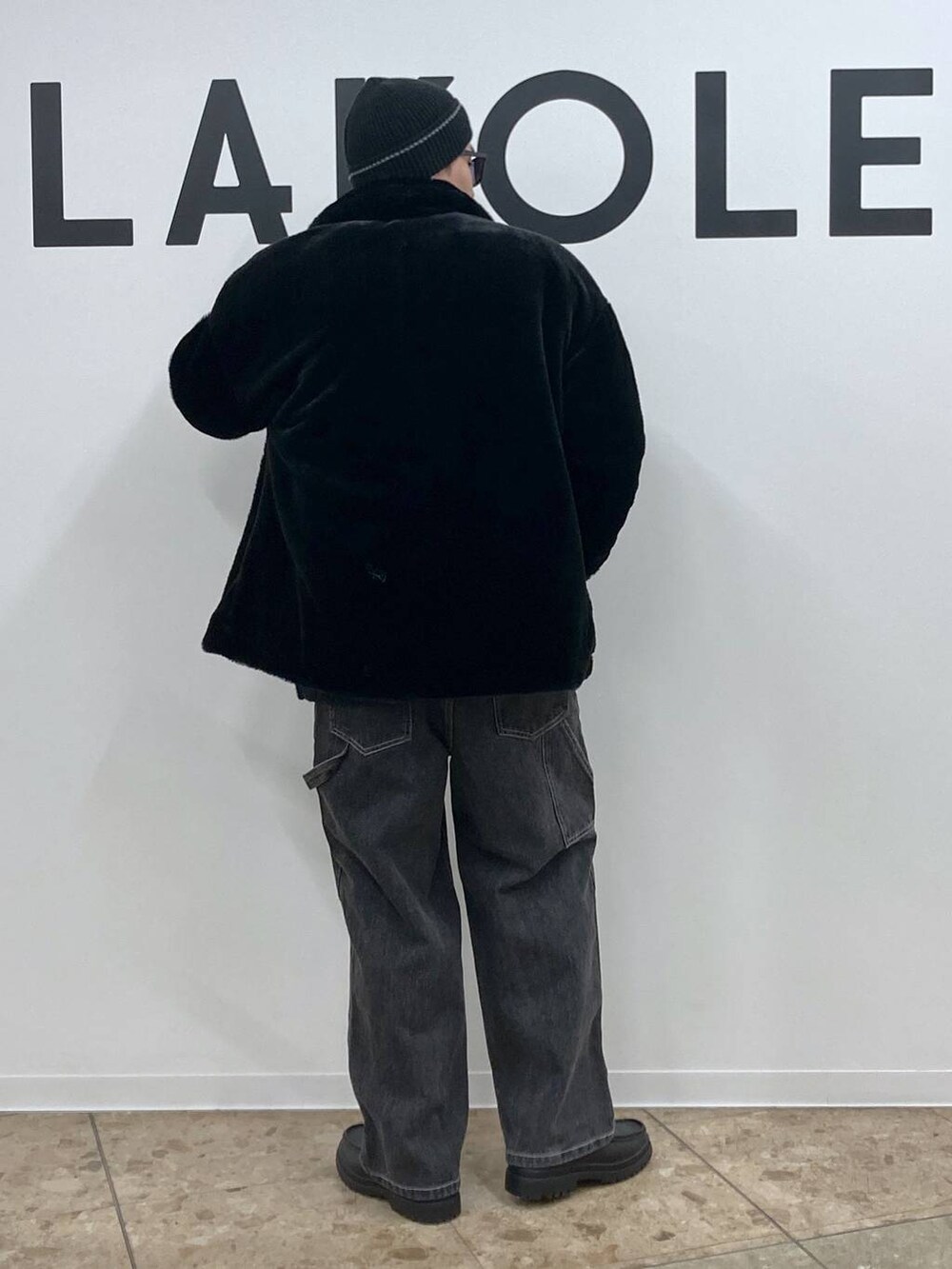 ブラック系のニット/セーター、グレー系のデニムパンツ、ブラック系のローファーを着用したメンズの冬コーディネートの2枚目の写真