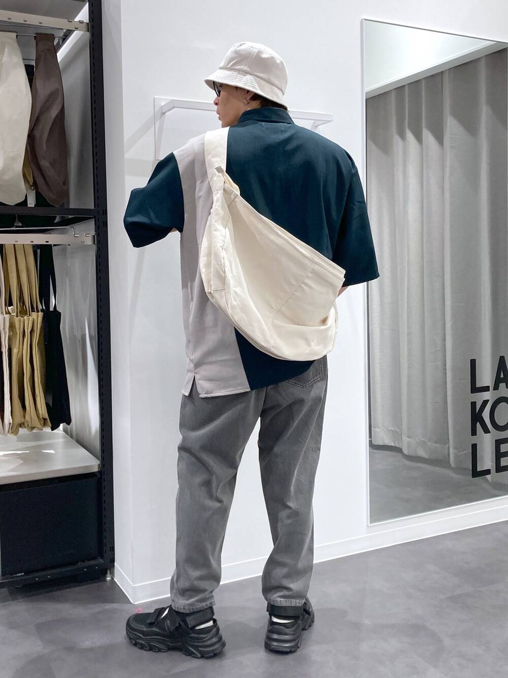 ブラック系のスニーカー、ベージュ系のショルダーバッグ、グリーン系のシャツ/ブラウスを着用したメンズの夏コーディネートの2枚目の写真