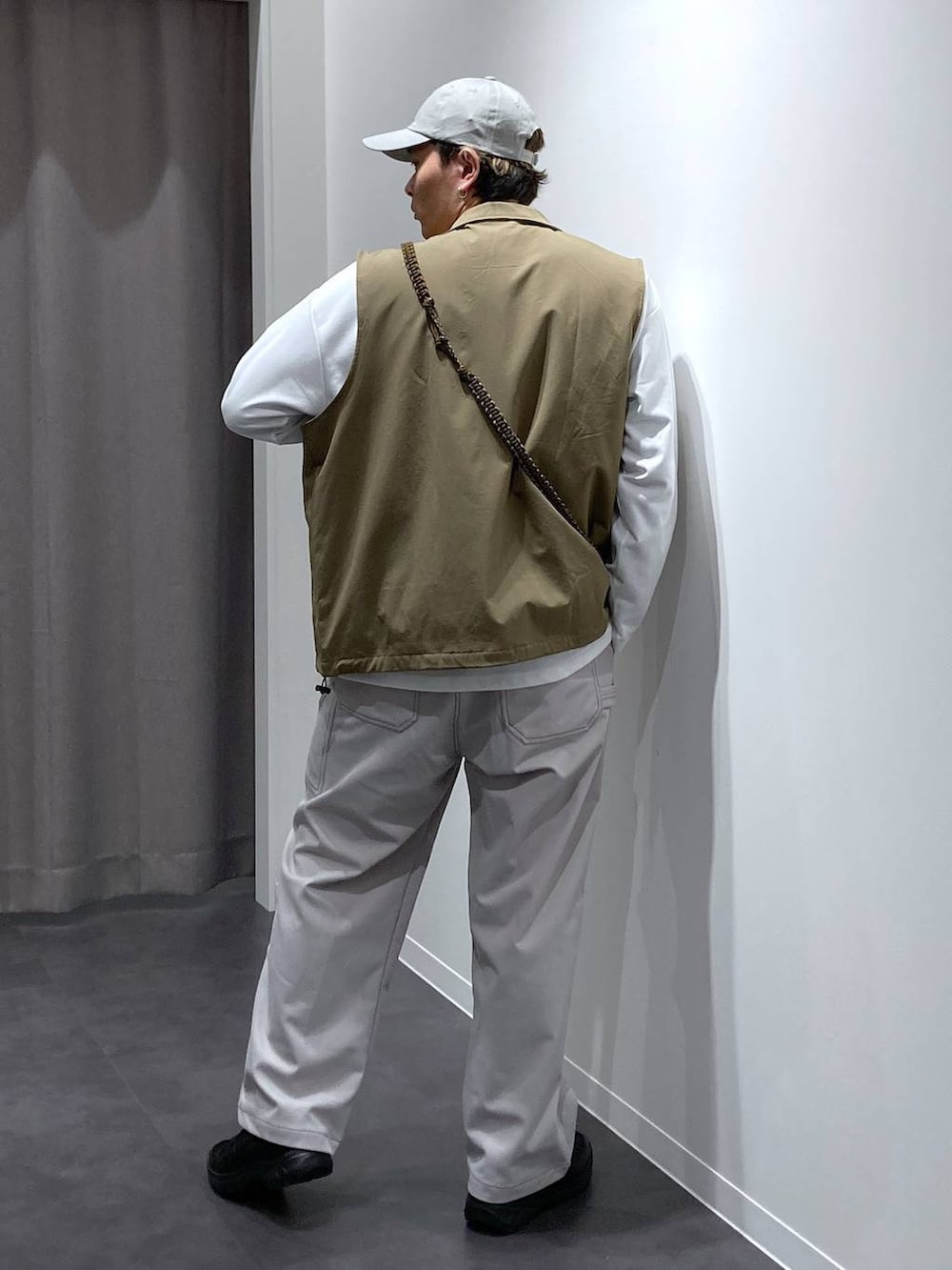 ベージュ系のベスト、グレー系のその他パンツ、ブラック系のスリッポンを着用したメンズの冬コーディネートの2枚目の写真