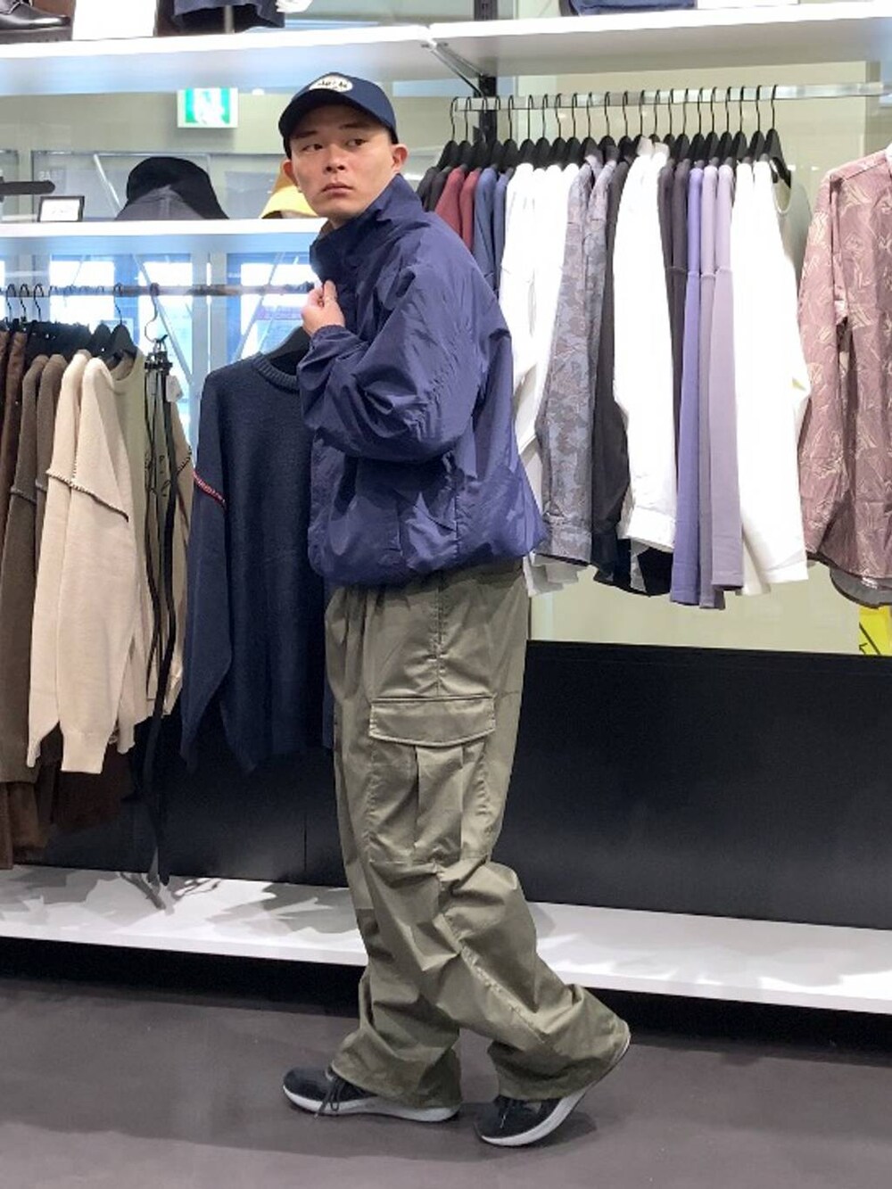 ブラック系のスニーカー、グリーン系のカーゴパンツ、ブルー系のキャップを着用したメンズの秋コーディネートの3枚目の写真