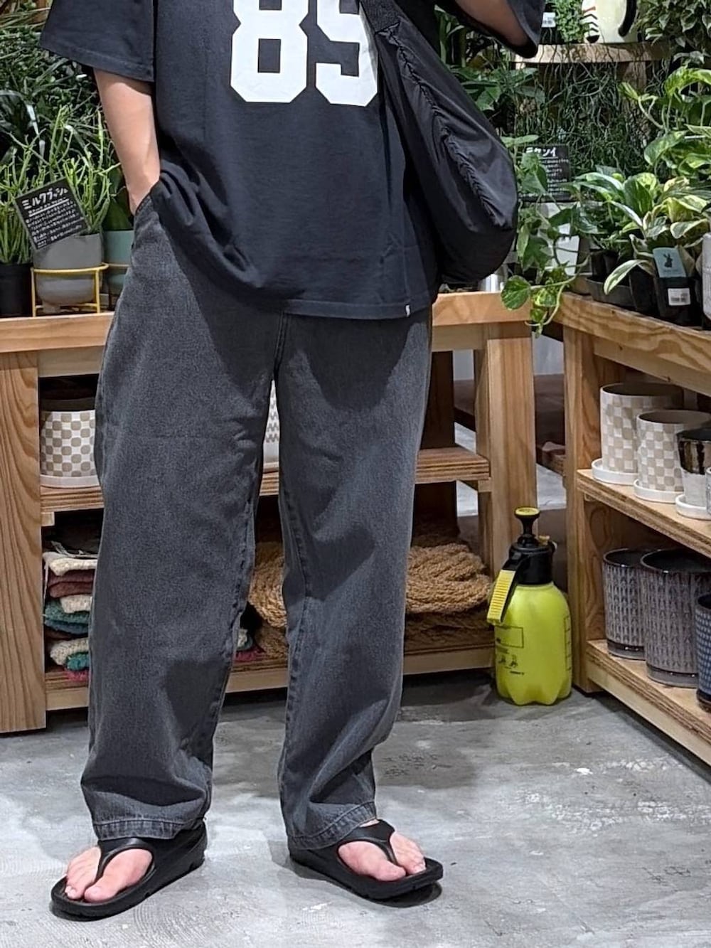 ブラック系のTシャツ/カットソー、ブラック系のエコバッグ/サブバッグ、ブラック系のサンダルを着用したメンズの夏コーディネートの7枚目の写真