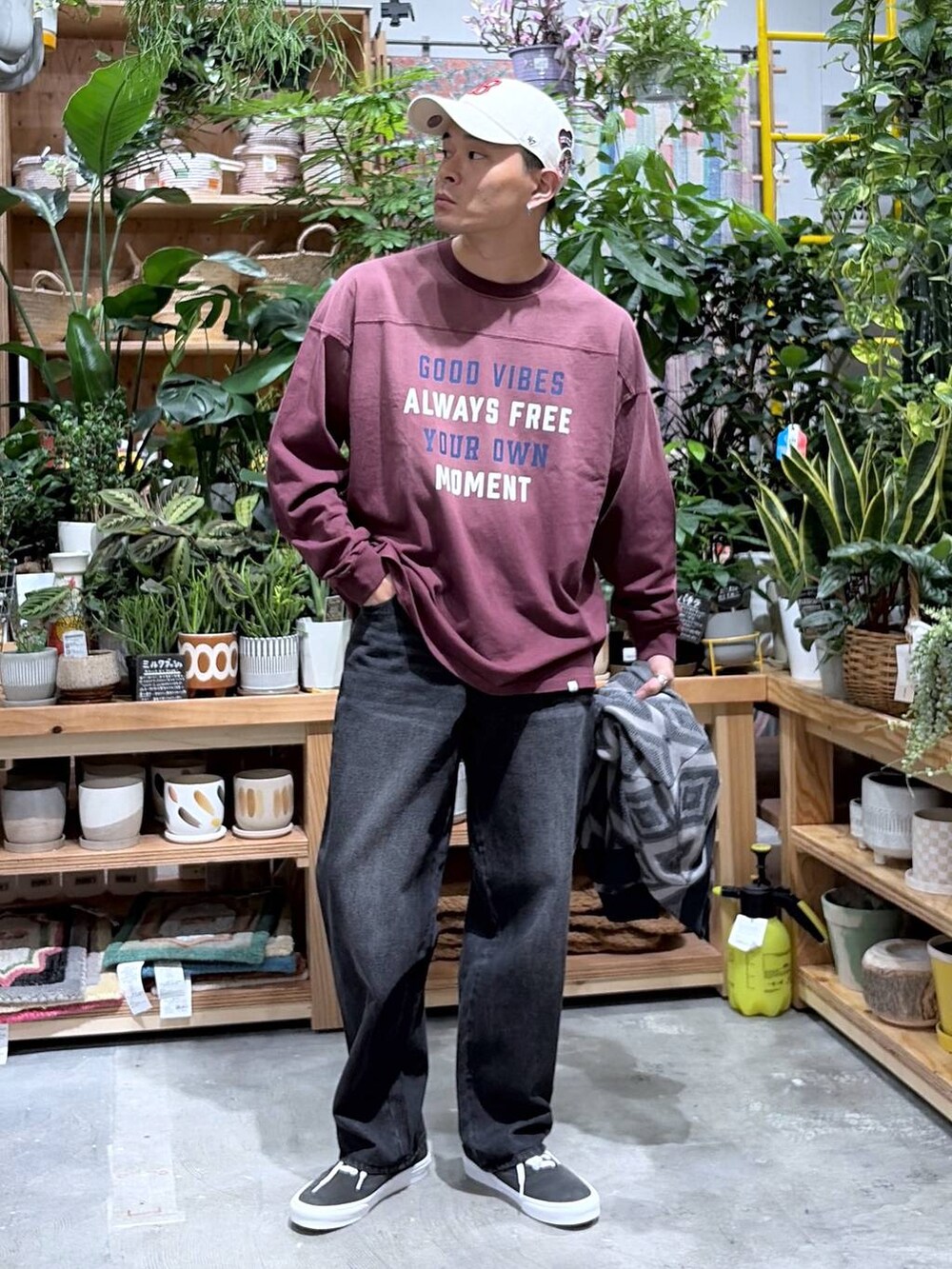 ブラック系のデニムパンツ、レッド系のTシャツ/カットソー、グレー系のカーディガン/ボレロを着用したメンズの秋コーディネートの5枚目の写真