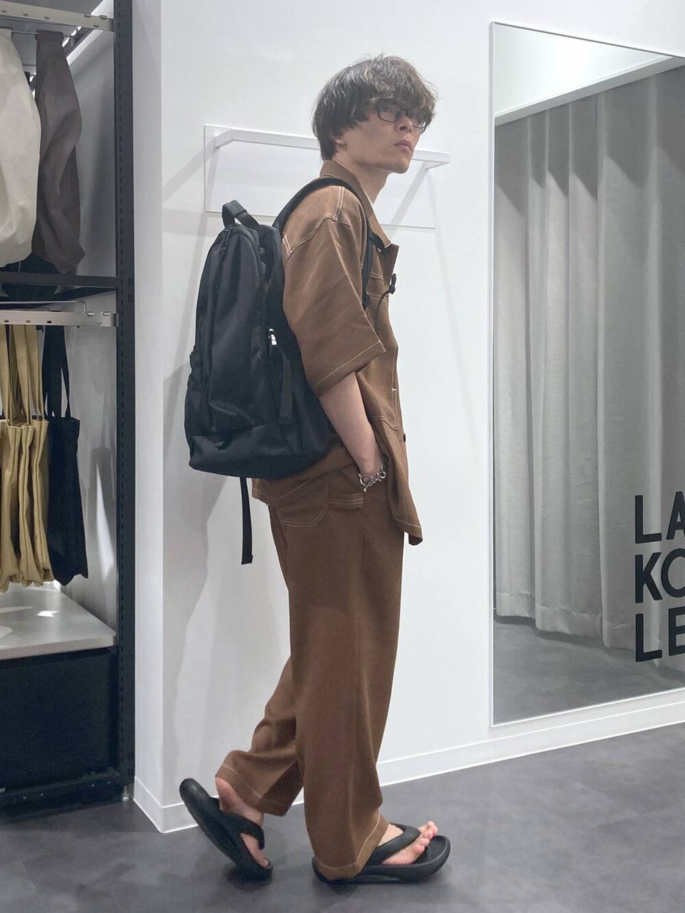 ブラック系のサンダル、ブラウン系のシャツ/ブラウス、ホワイト系のTシャツ/カットソーを着用したメンズの夏コーディネートの4枚目の写真