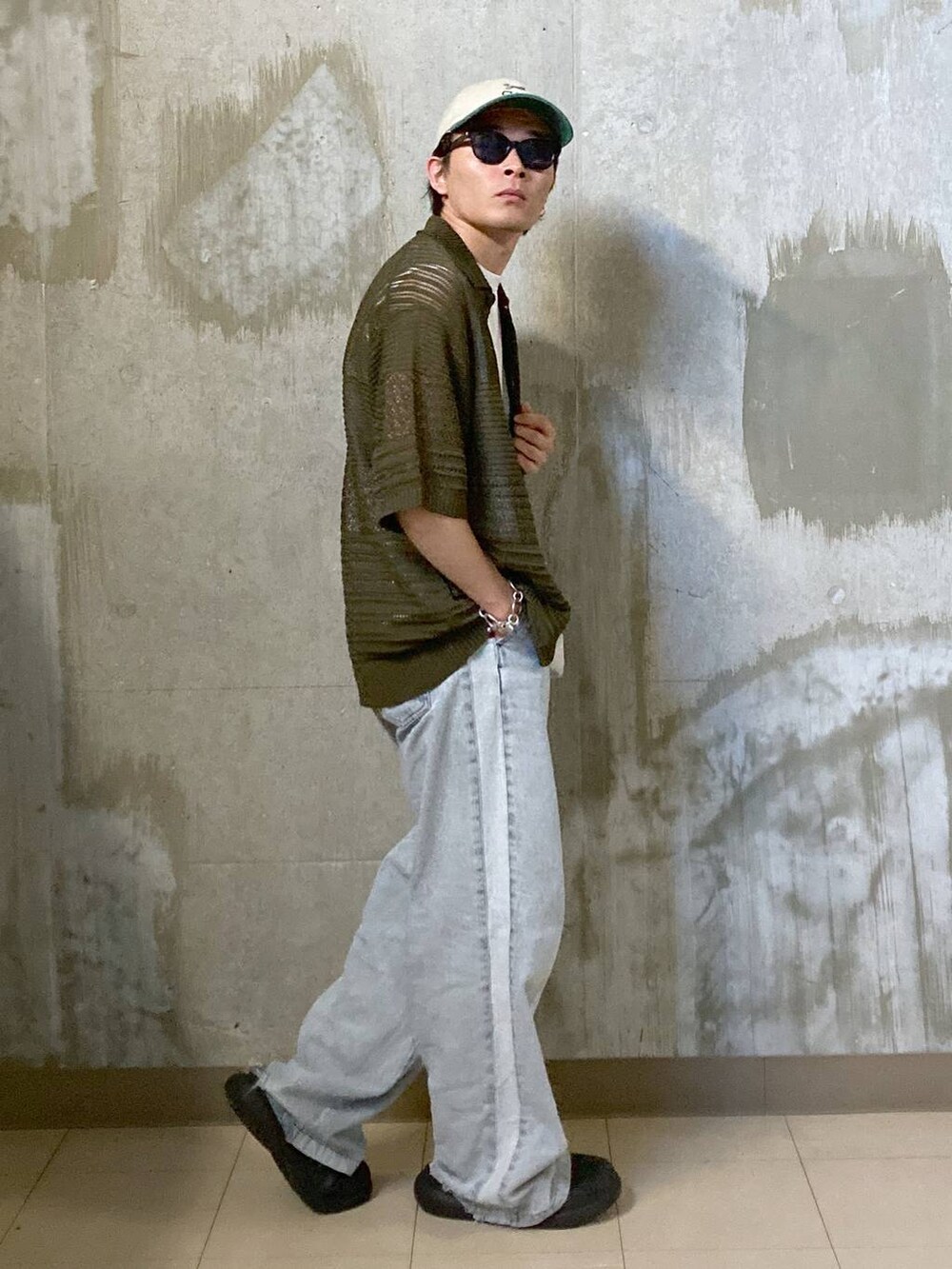 ホワイト系のTシャツ/カットソー、グリーン系のニット/セーター、ブラック系のサングラスを着用したメンズの夏コーディネートの3枚目の写真