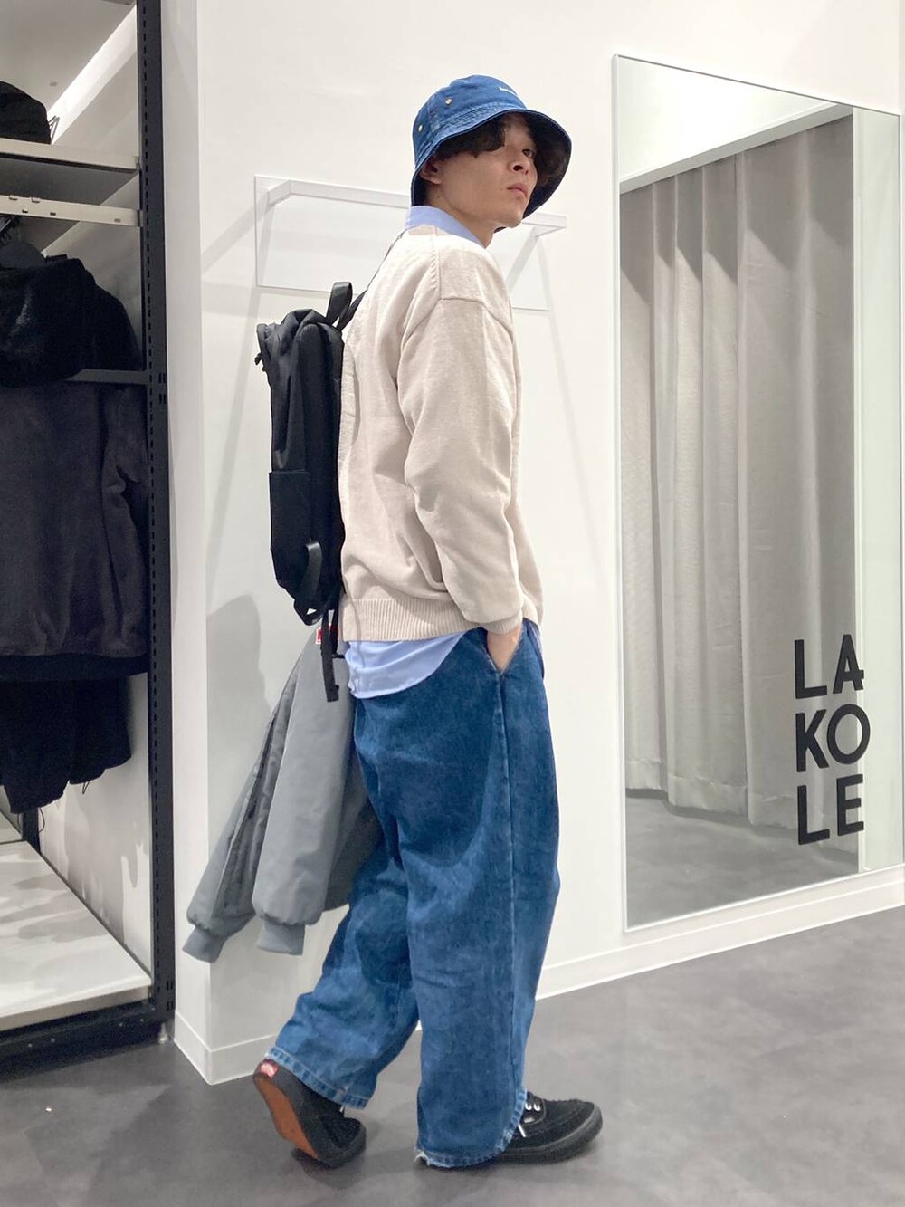 ブラック系のバックパック/リュック、ブルー系のシャツ/ブラウス、ベージュ系のニット/セーターを着用したメンズの冬コーディネートの5枚目の写真