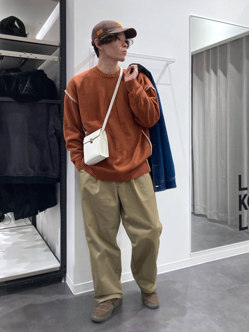 ブルー系のデニムジャケット、ベージュ系のチノパンツ、オレンジ系のニット/セーターを着用したメンズの冬コーディネートの4枚目の写真