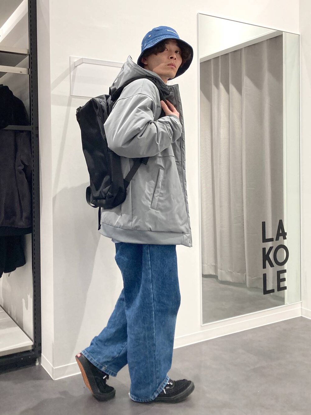 ブラック系のバックパック/リュック、ブルー系のシャツ/ブラウス、ベージュ系のニット/セーターを着用したメンズの冬コーディネートの8枚目の写真