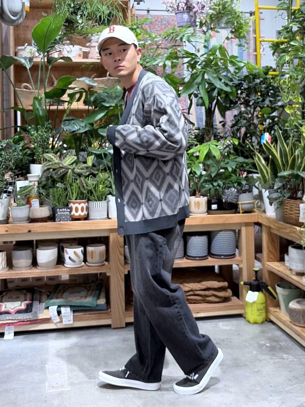 ブラック系のデニムパンツ、レッド系のTシャツ/カットソー、グレー系のカーディガン/ボレロを着用したメンズの秋コーディネートの3枚目の写真