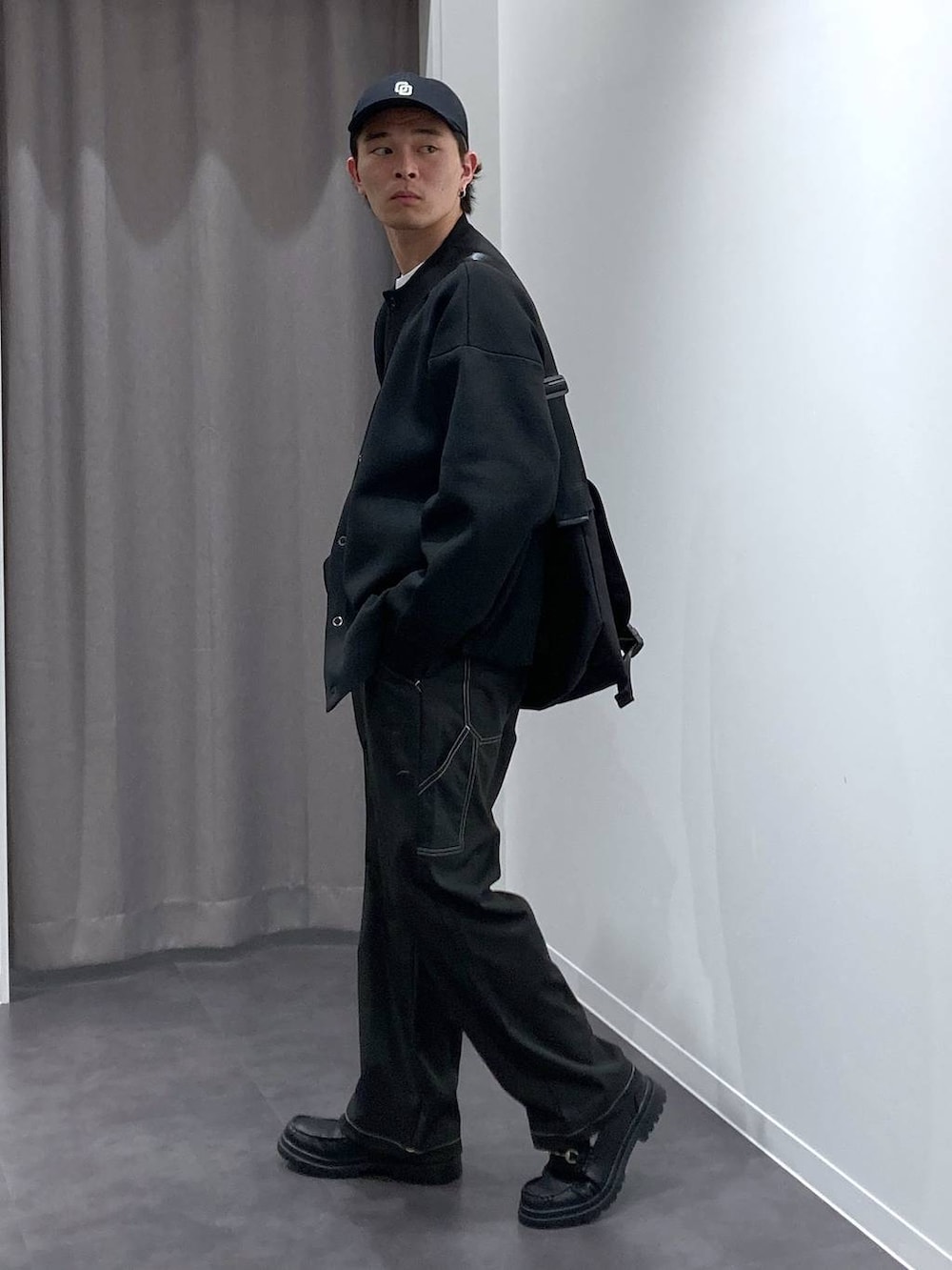 ブラック系のその他パンツ、ブラック系のローファー、ブラック系のメッセンジャーバッグを着用したメンズの冬コーディネートの4枚目の写真