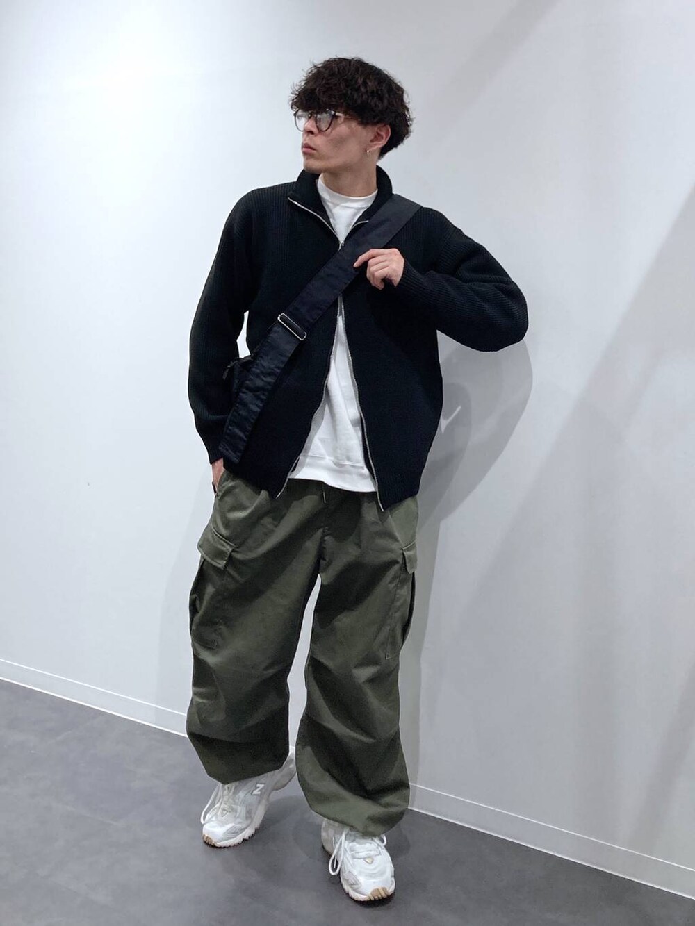 ホワイト系のスニーカー、ホワイト系のスウェット、グリーン系のカーゴパンツを着用したメンズの秋コーディネートの3枚目の写真