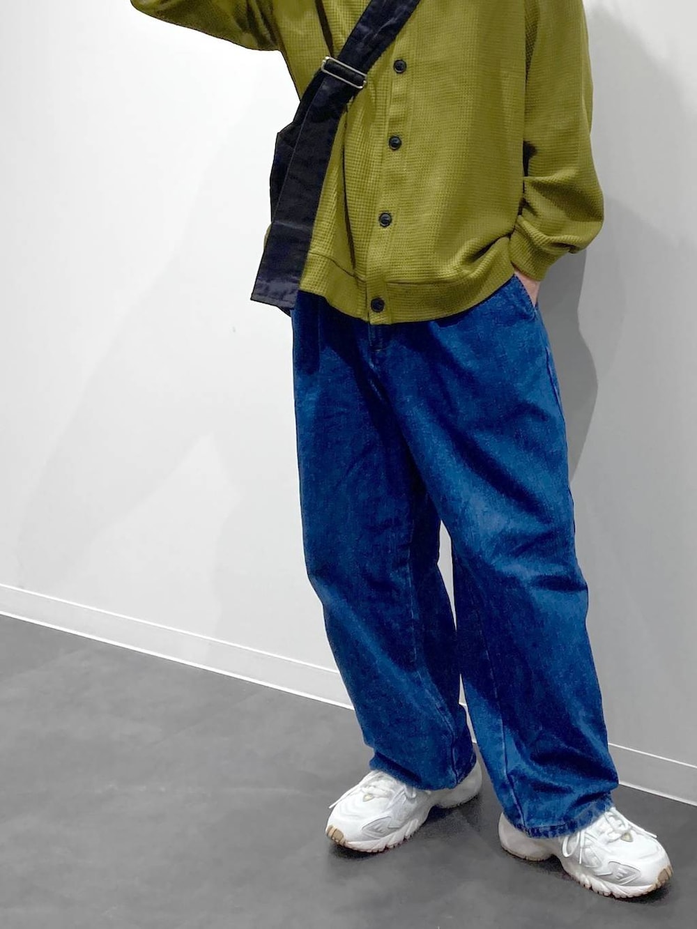 ホワイト系のスニーカー、イエロー系のTシャツ/カットソー、ブルー系のデニムパンツを着用したメンズの秋コーディネートの7枚目の写真