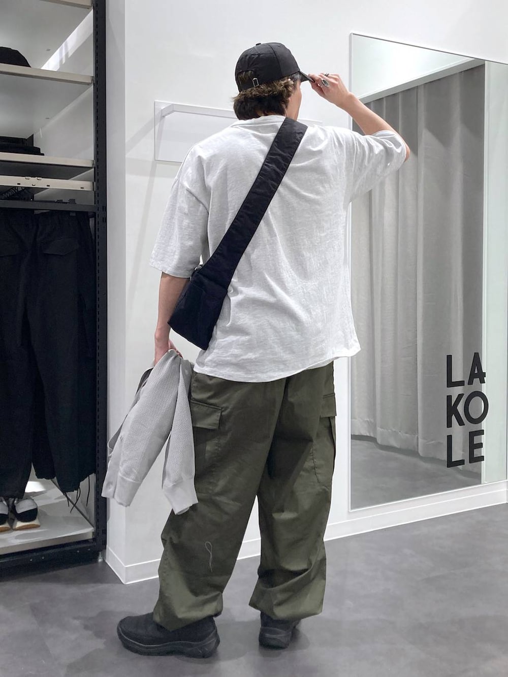 グレー系のTシャツ/カットソー、ブラック系のスリッポン、グリーン系のカーゴパンツを着用したメンズの春コーディネートの5枚目の写真