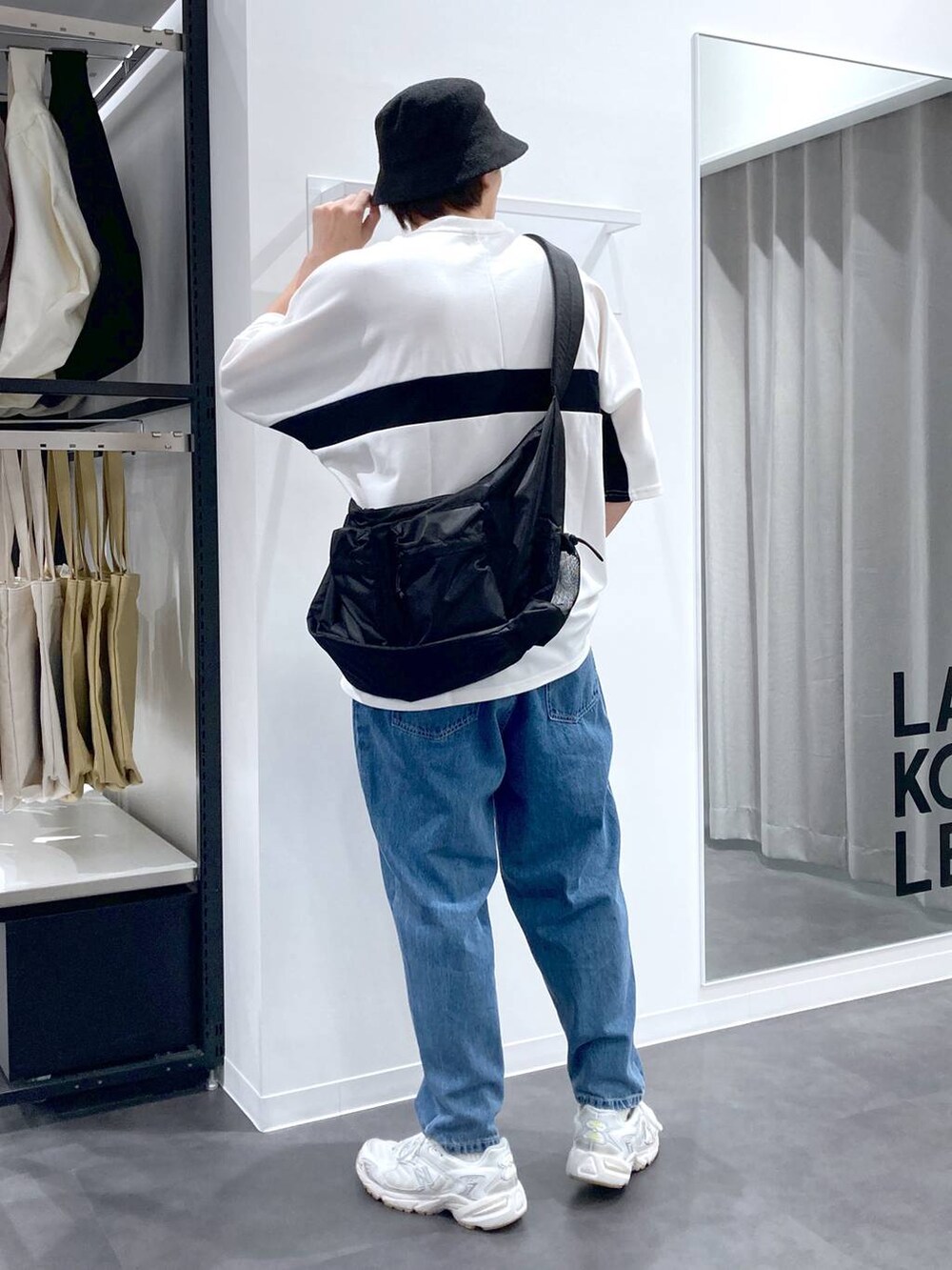 ホワイト系のTシャツ/カットソー、ブラック系のショルダーバッグ、ブルー系のデニムパンツを着用したメンズの夏コーディネートの2枚目の写真